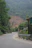 Winding road through green mountains with a visible landslide.