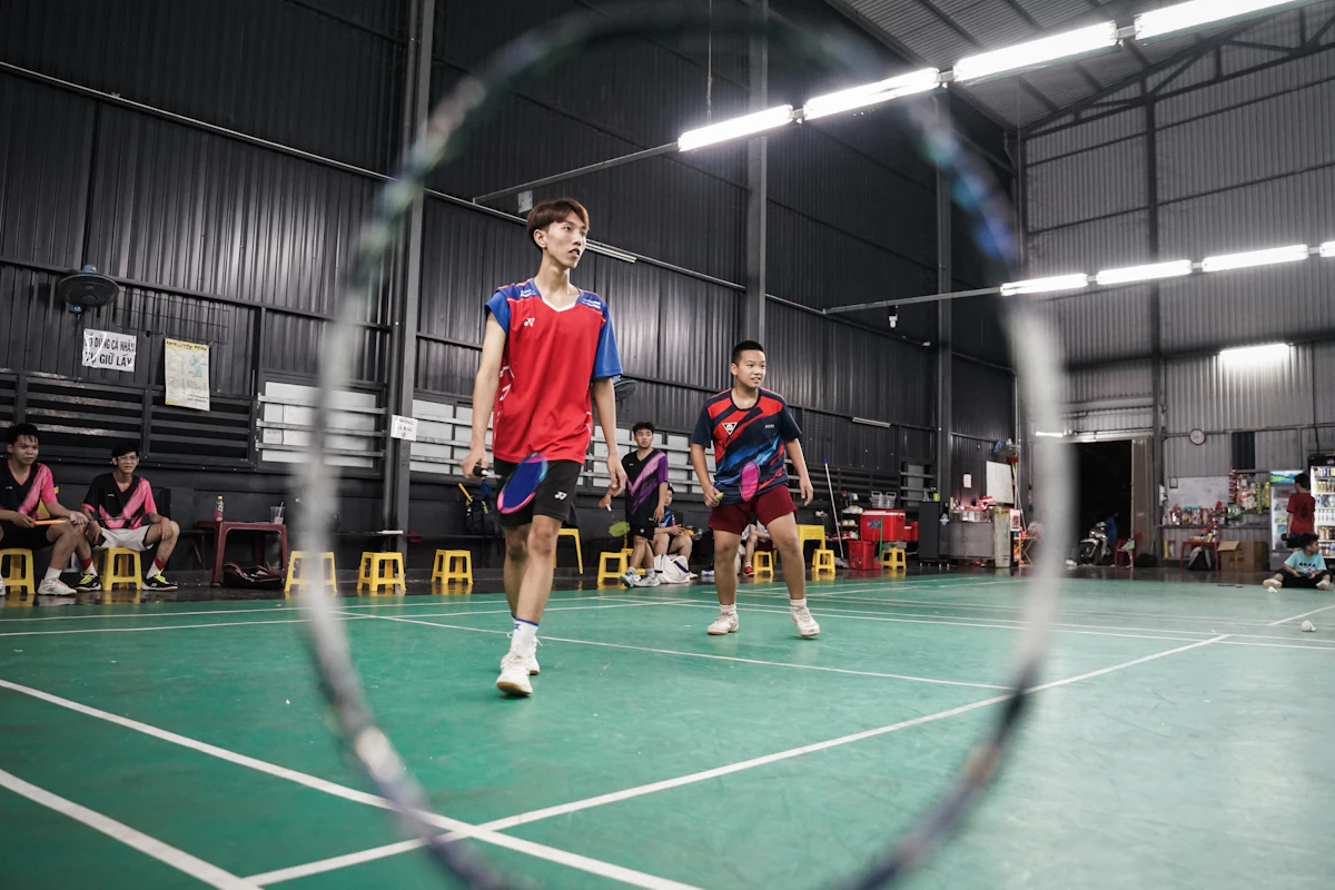 Badminton players practicing on an indoor court