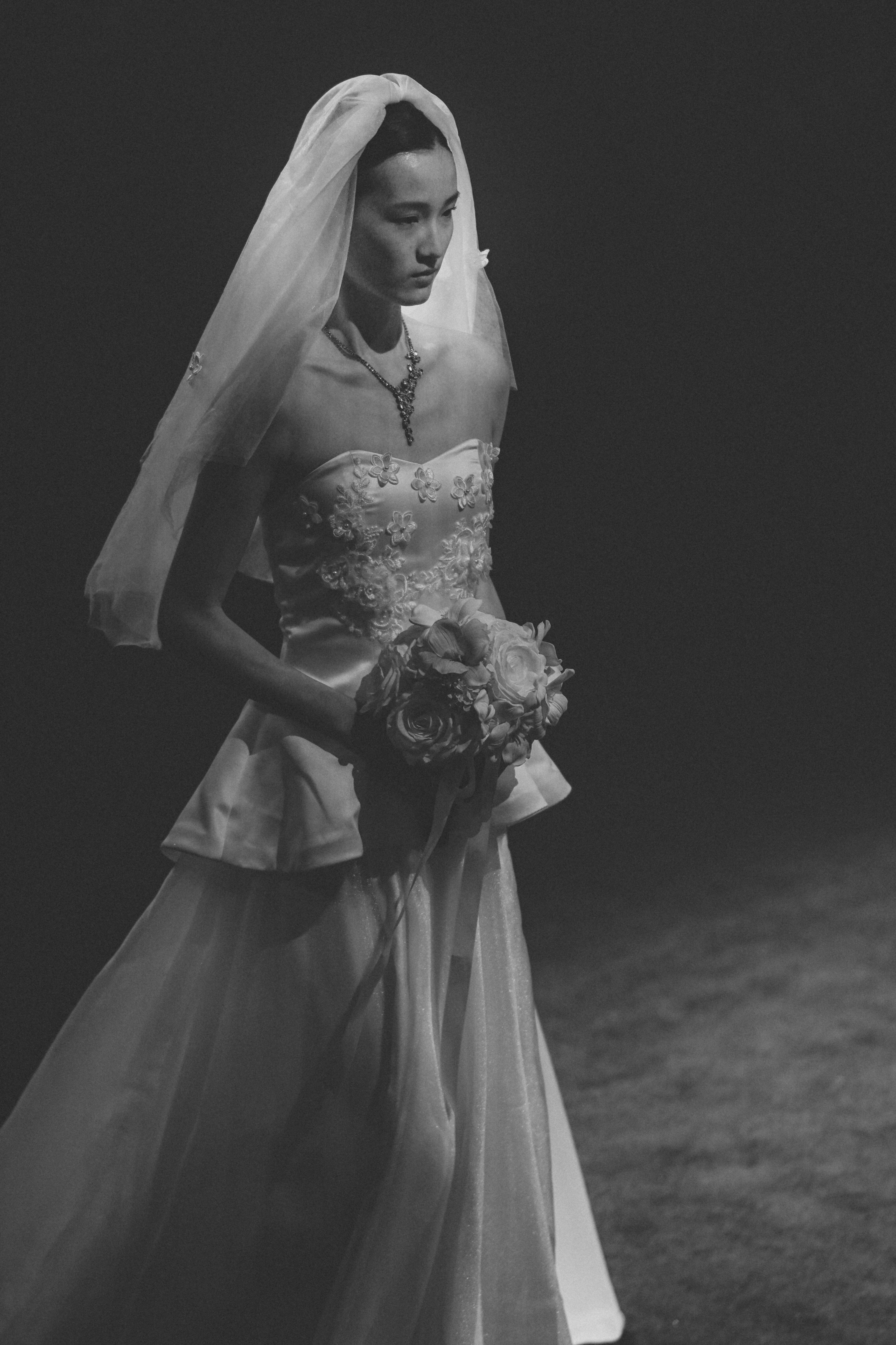 A bride in a wedding dress holding a bouquet.