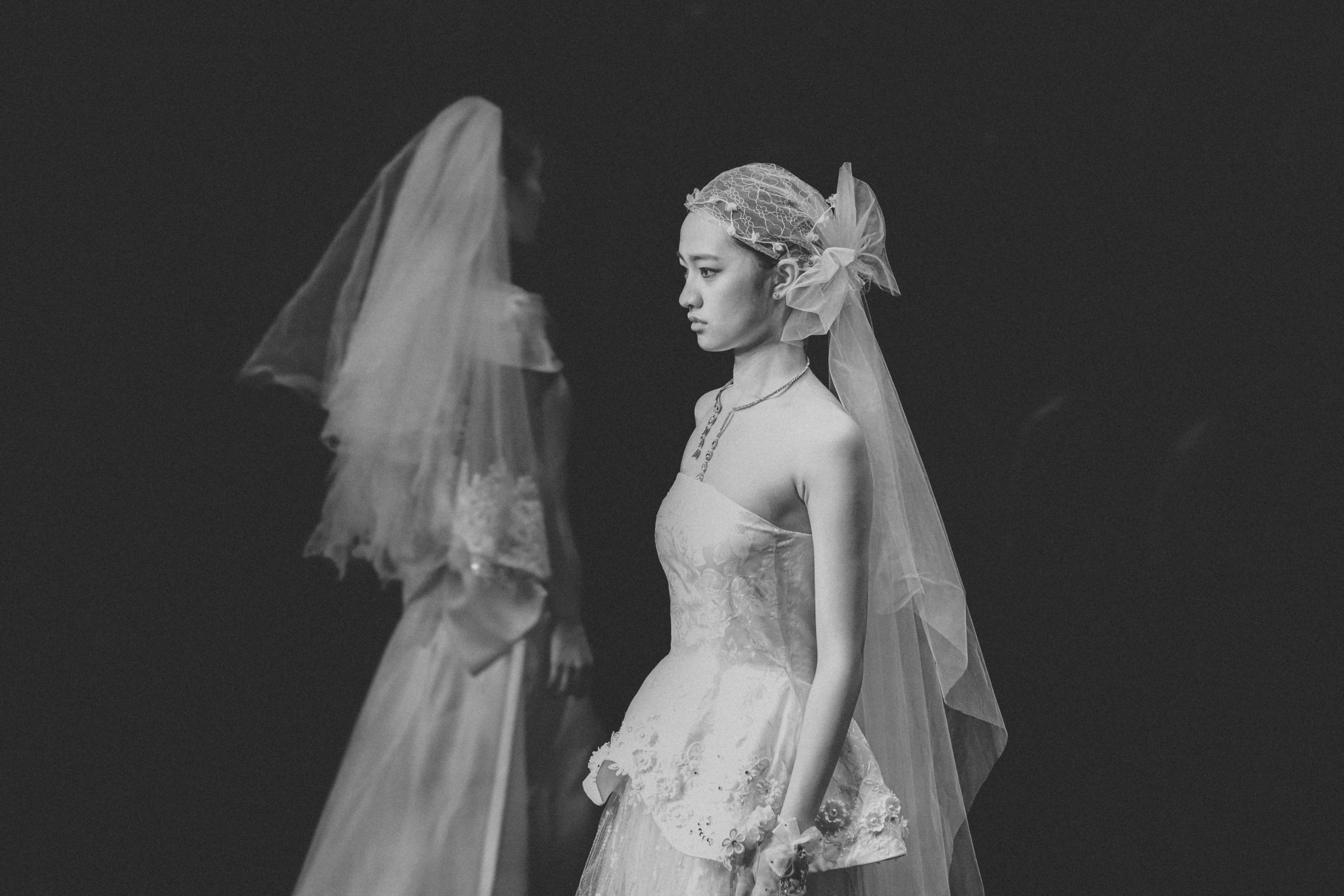 A woman in a wedding dress with a ghostly reflection.