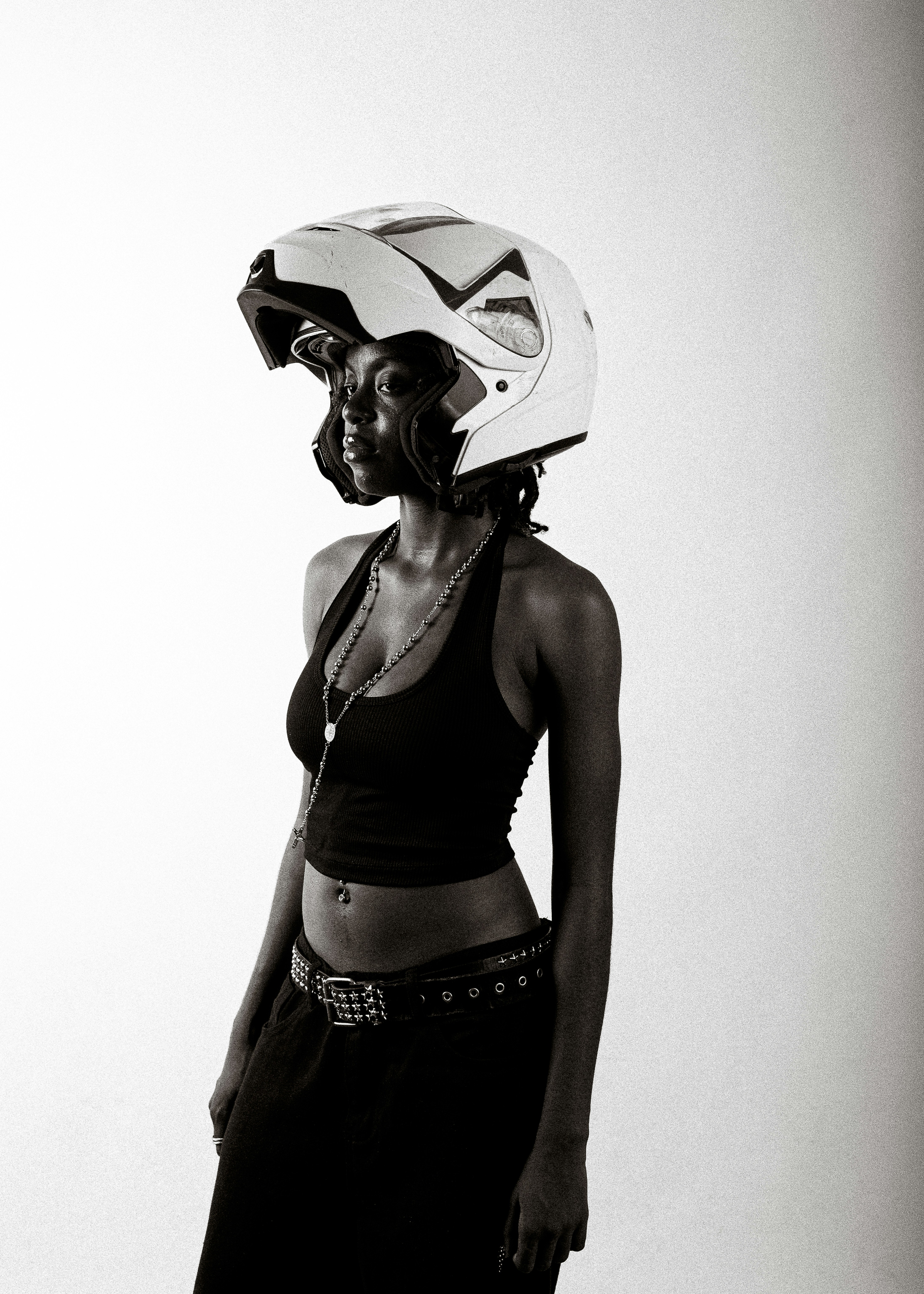黒い服を着て白いバイクのヘルメットをかぶった女性。