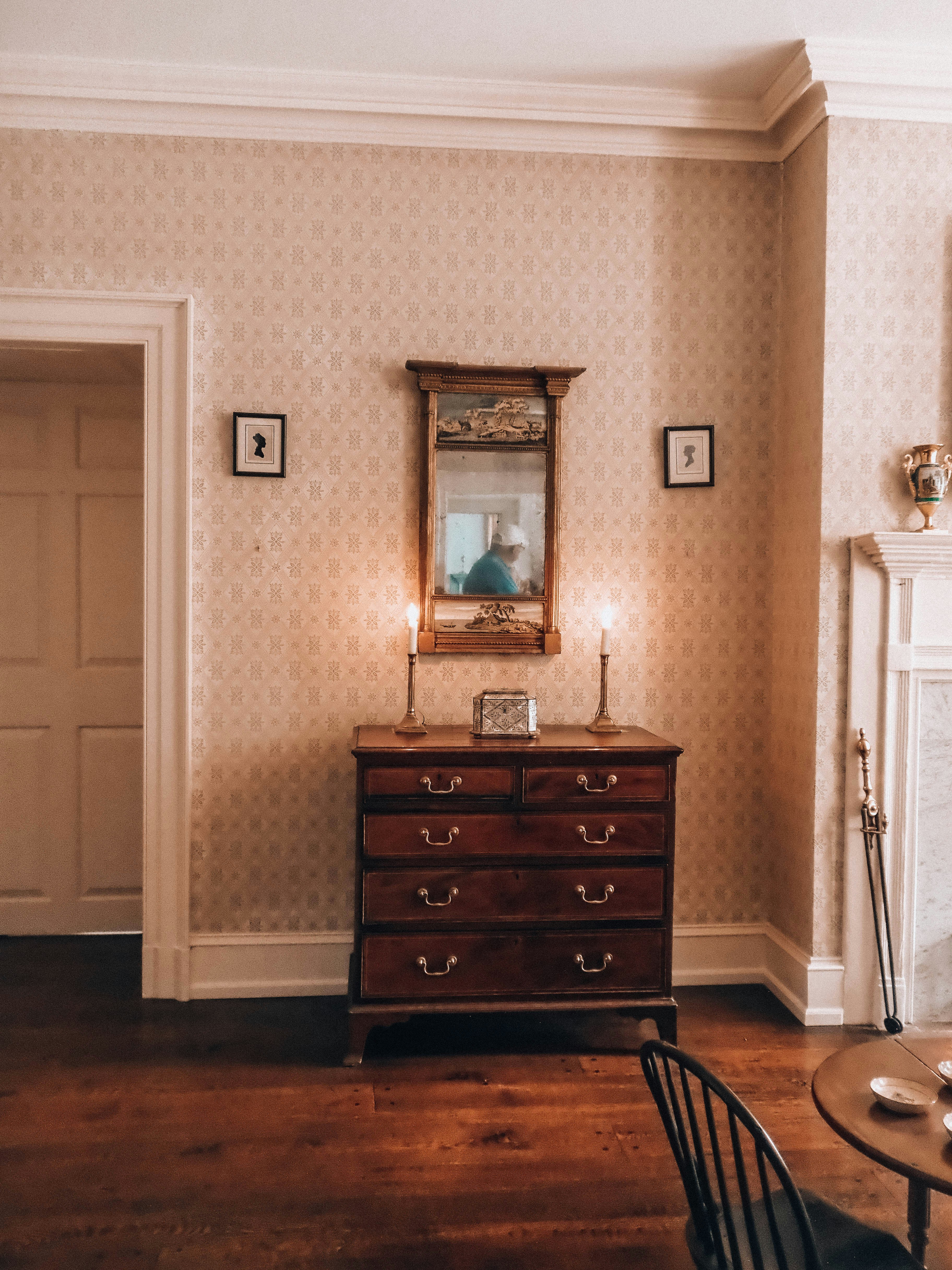 Elegant room with antique dresser, lit candles, and mirror.