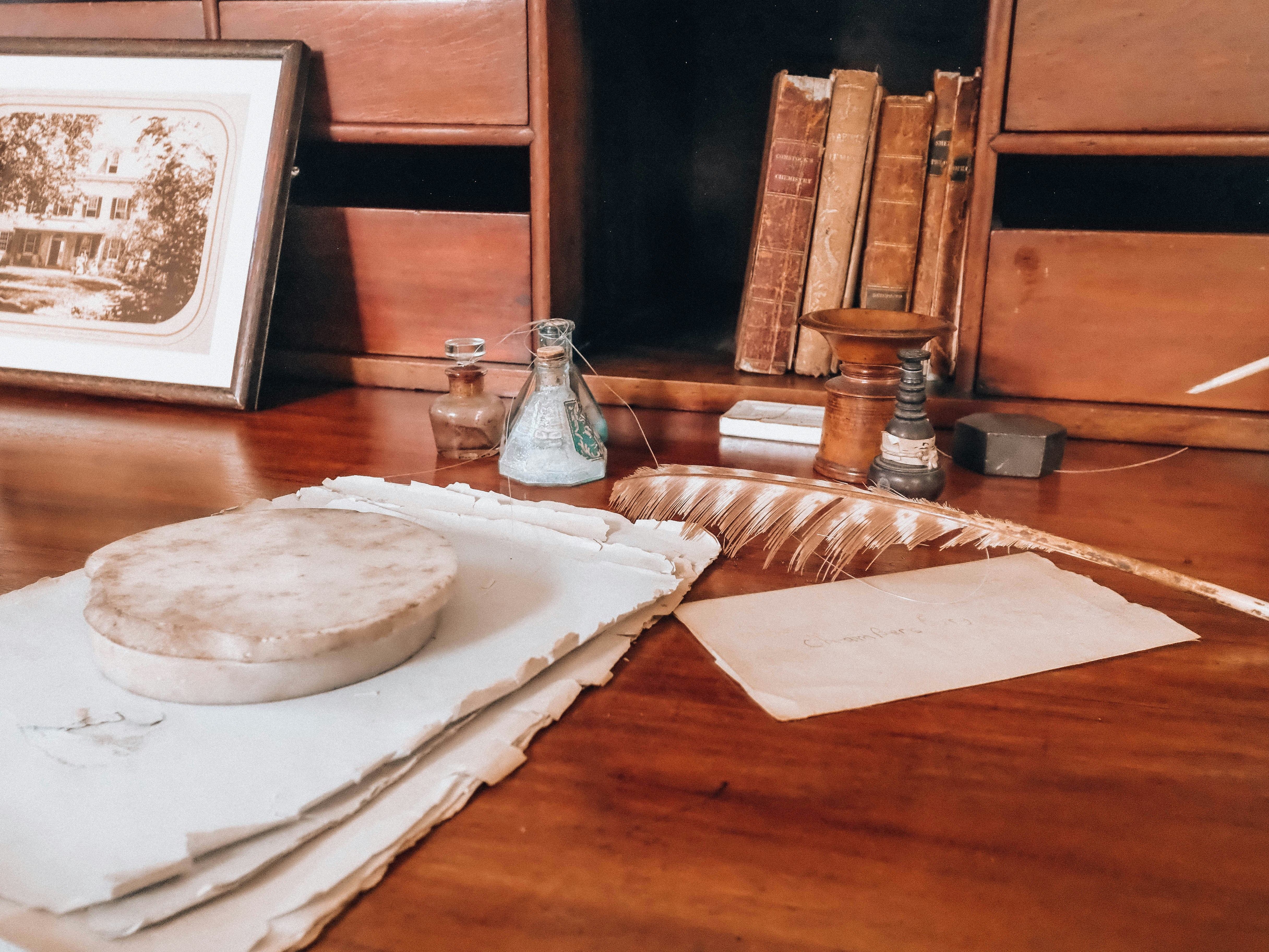 patent certificate with legal documents on desk - An antique wooden desk with quill, papers, and old books.