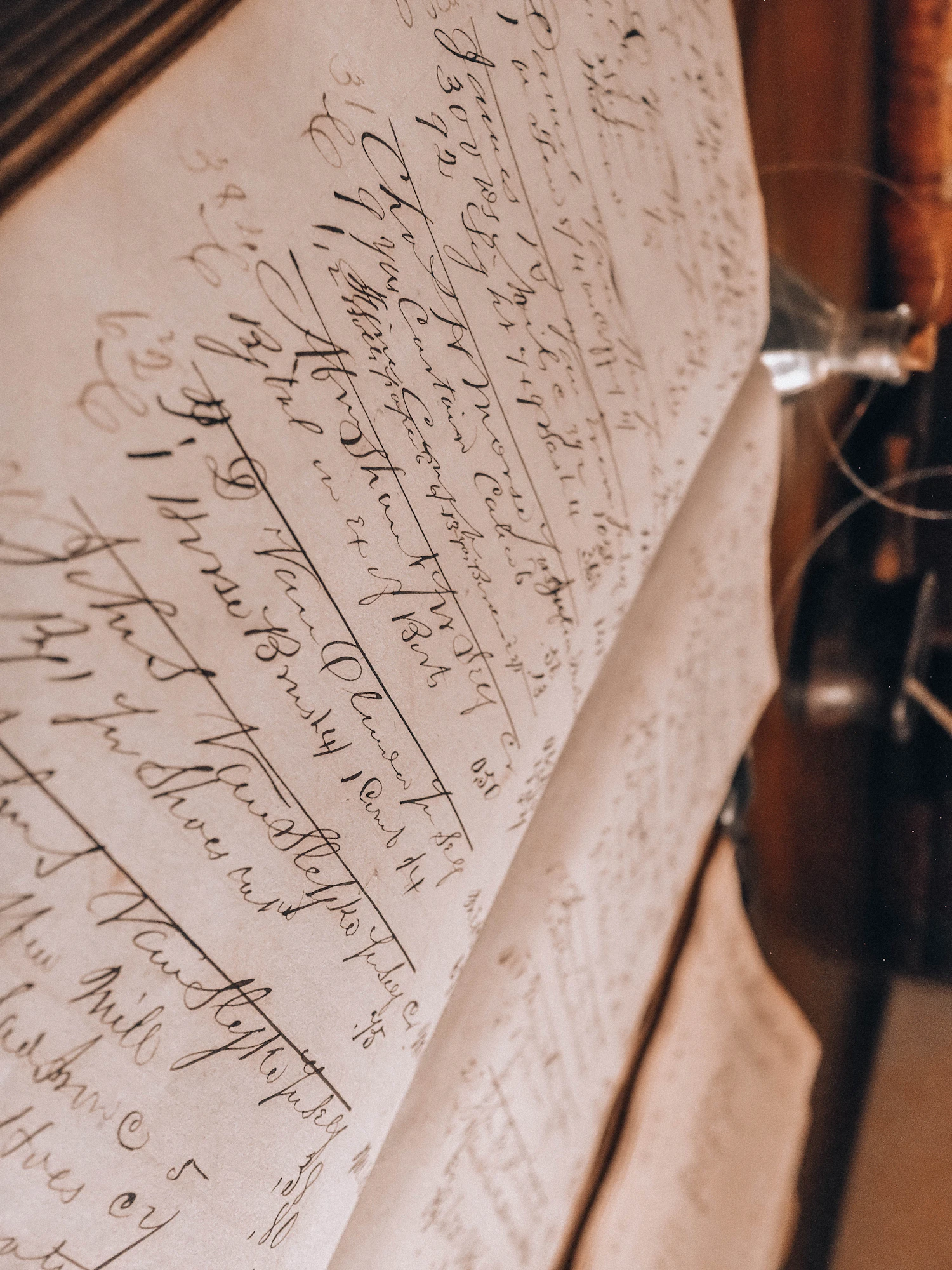A ledger lying open at two pages of close handwriting beside a glass inkwell