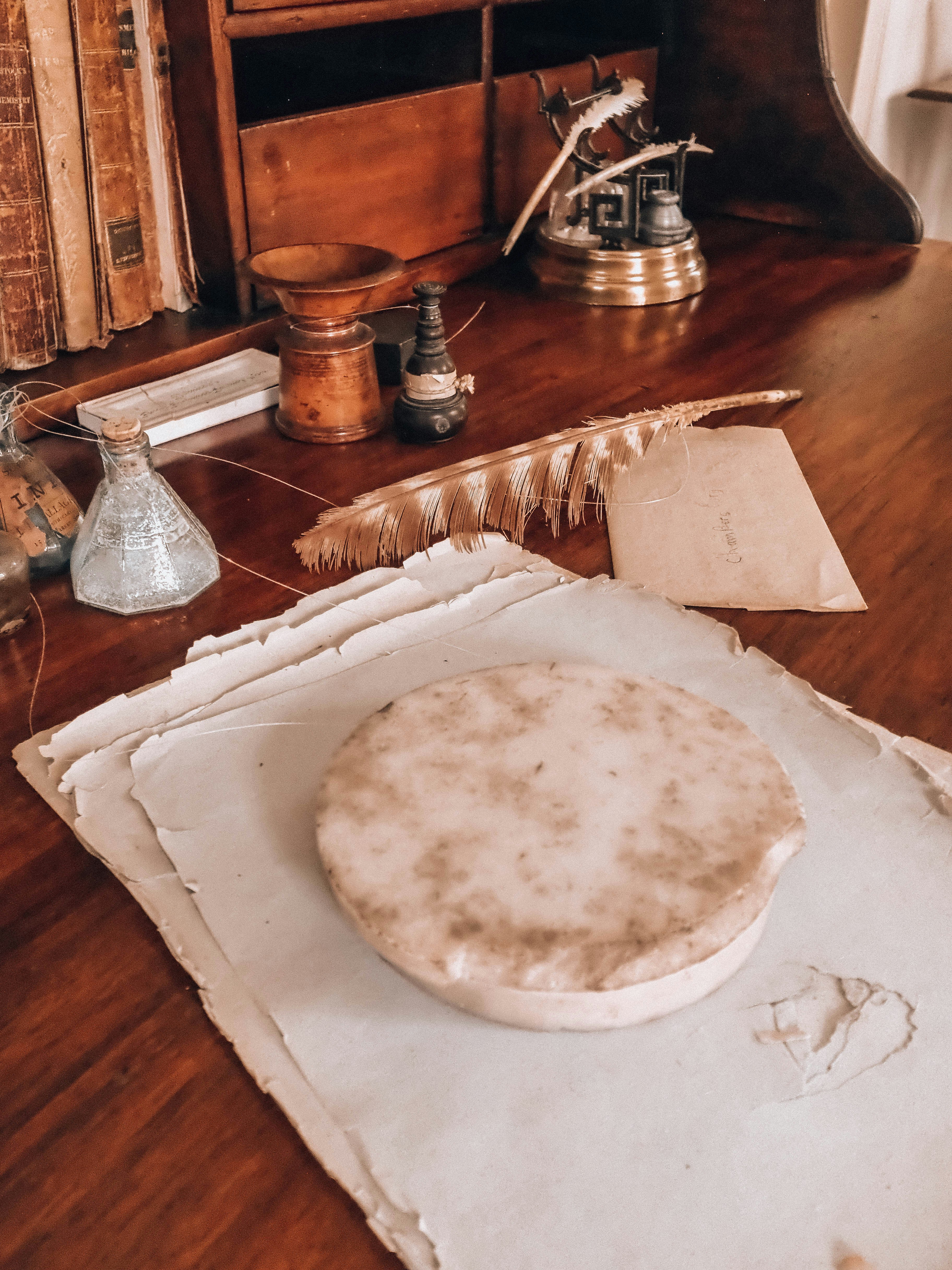 Antique writing desk with quill, inkwells, and old papers.