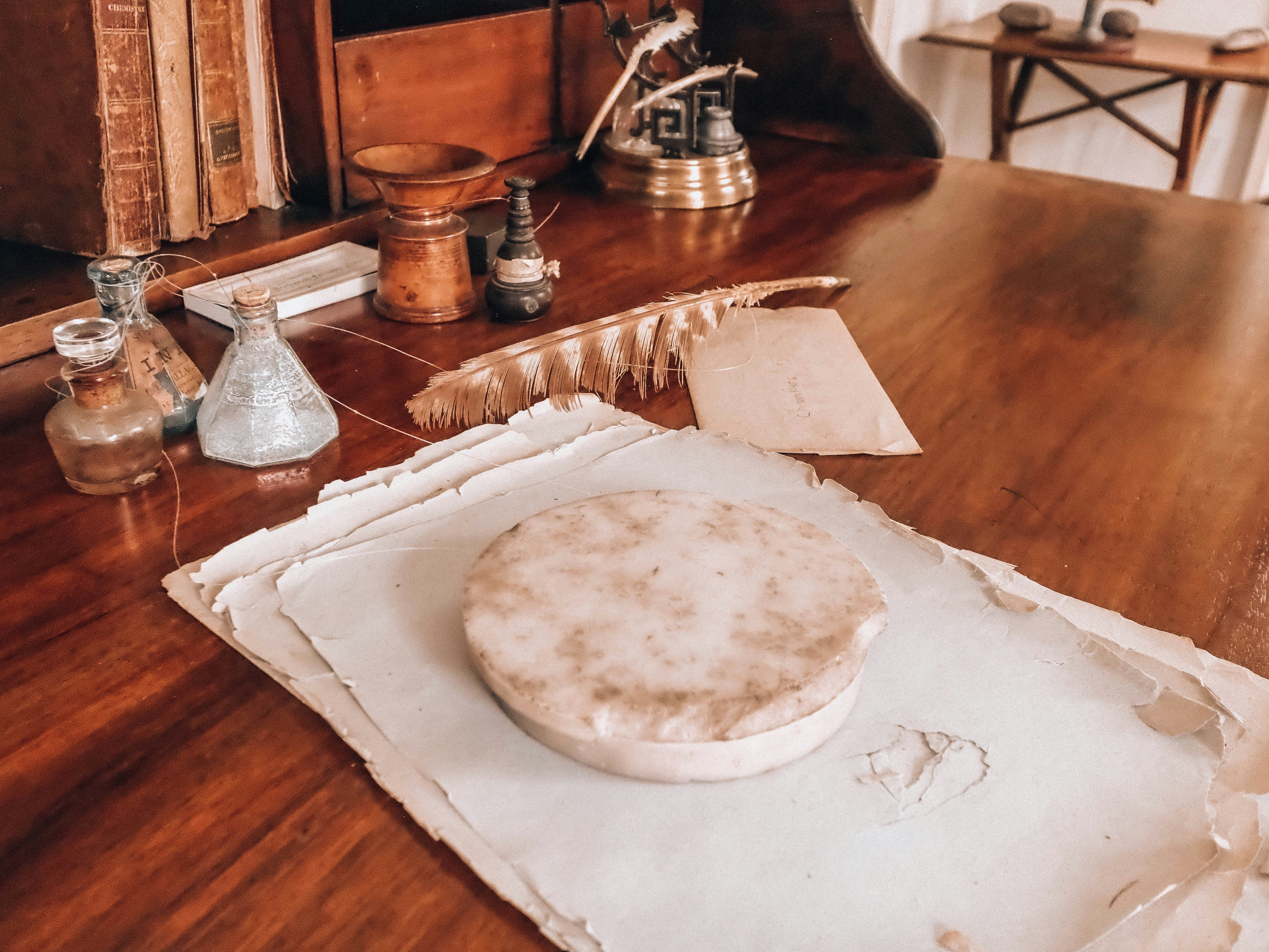 Antique wooden desk with old papers, inkwells, and quill pen.