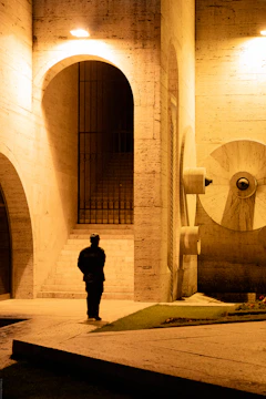 Guard stands in an arched concrete building at night