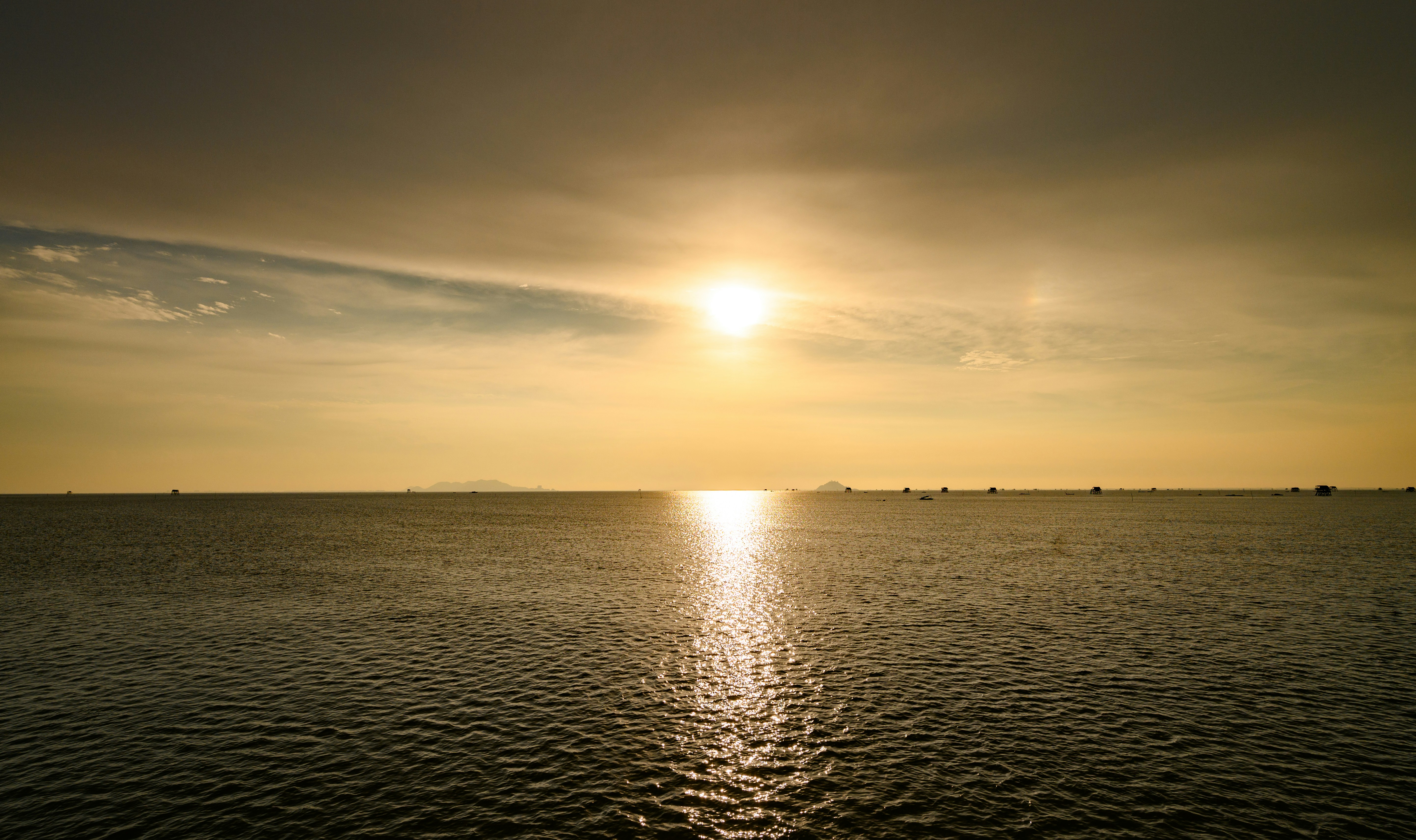 Golden sunset reflecting on the calm ocean surface.