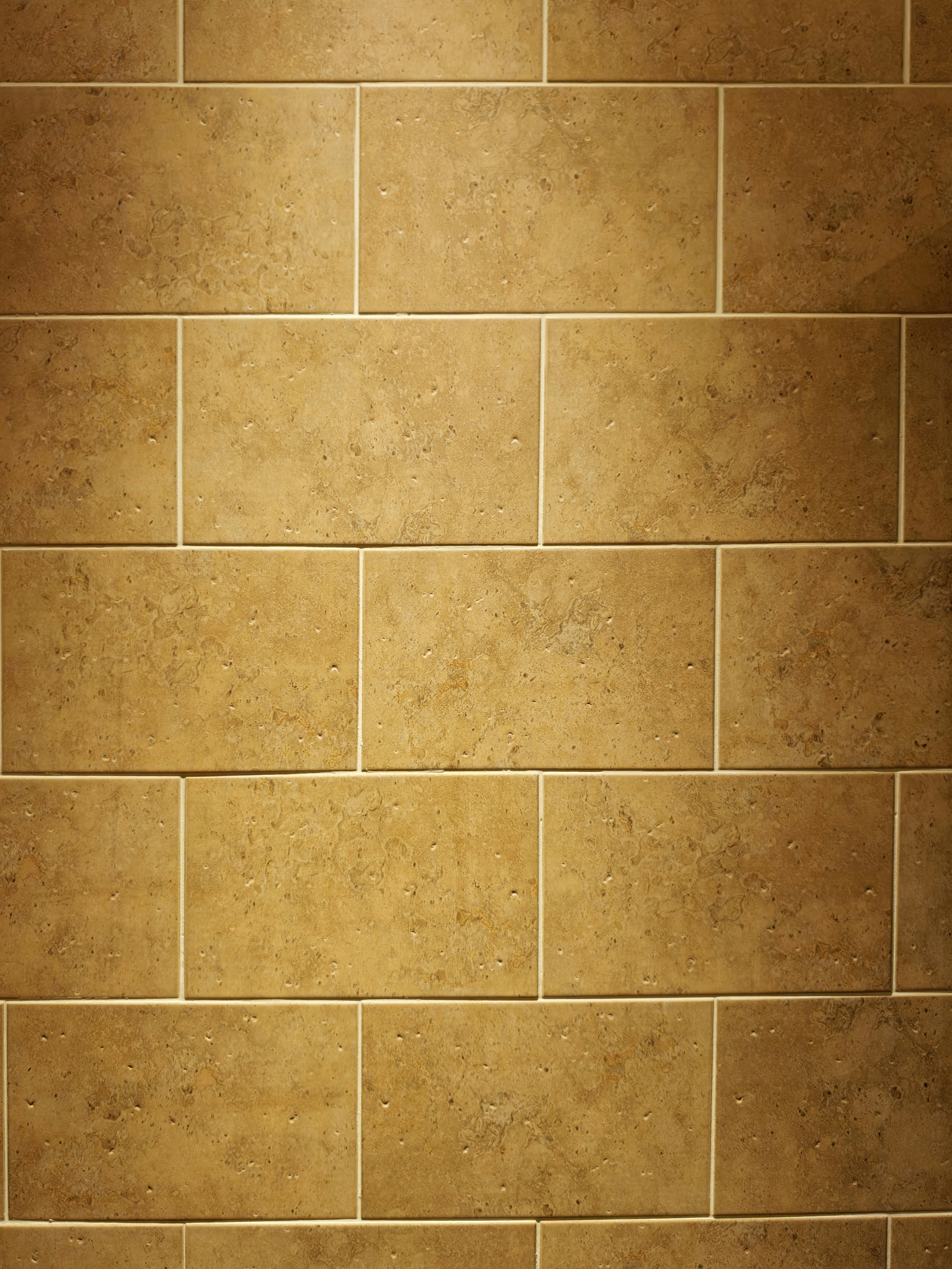 Tan rectangular wall tiles with light grout lines.
