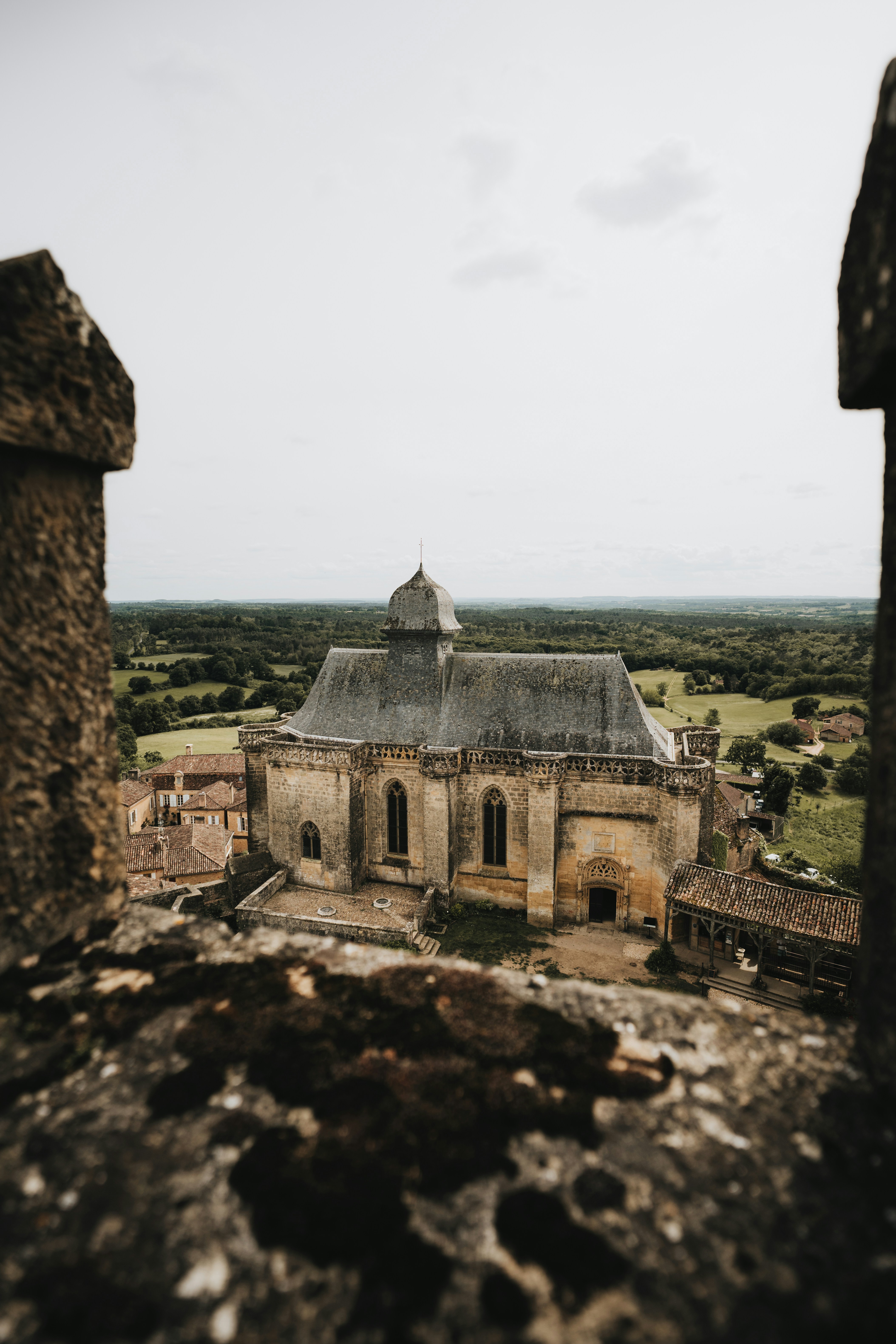 Old stone church framed by walls overlooking rural landscape.