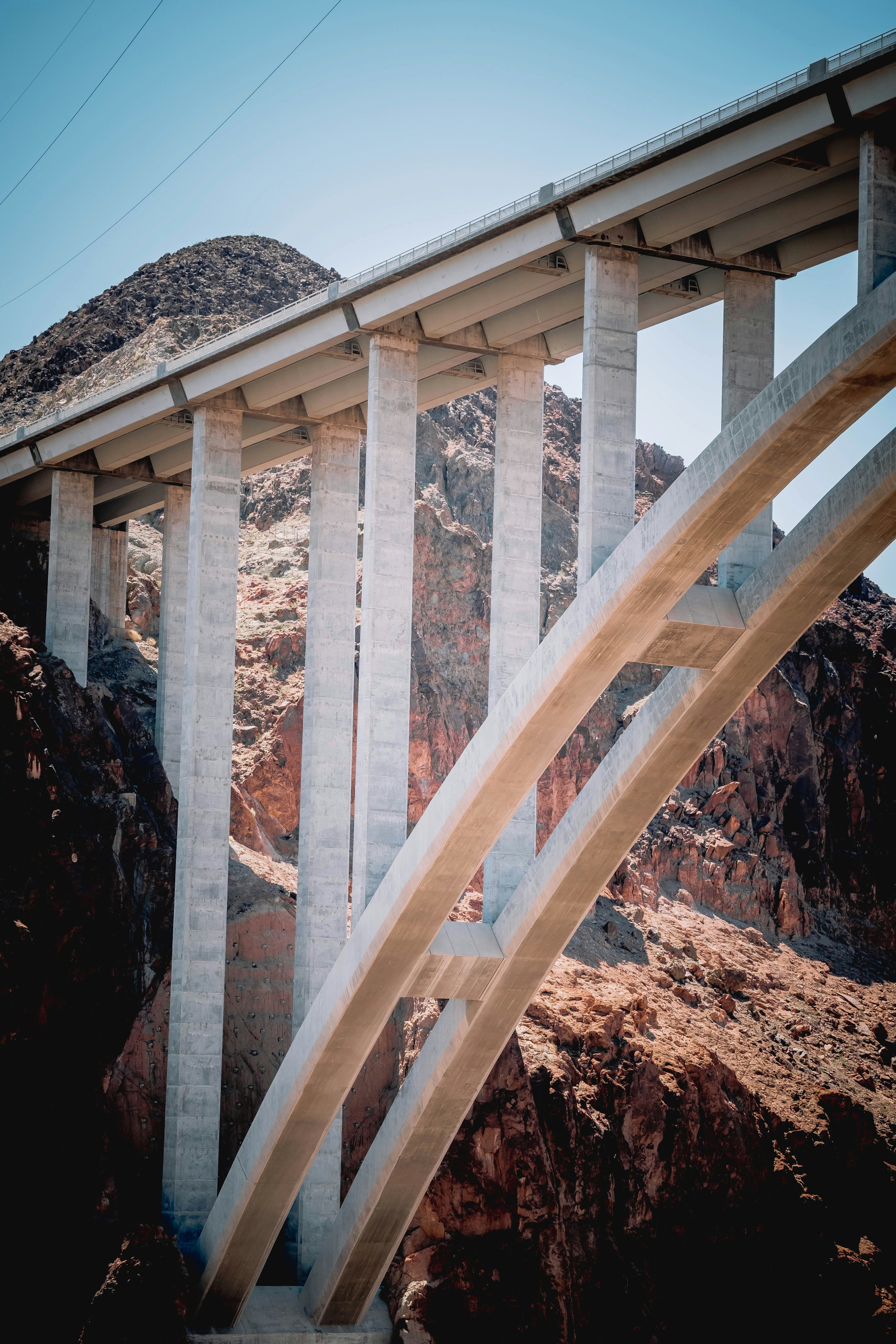 Eine massive Betonbrücke überspannt eine zerklüftete Wüstenschlucht.