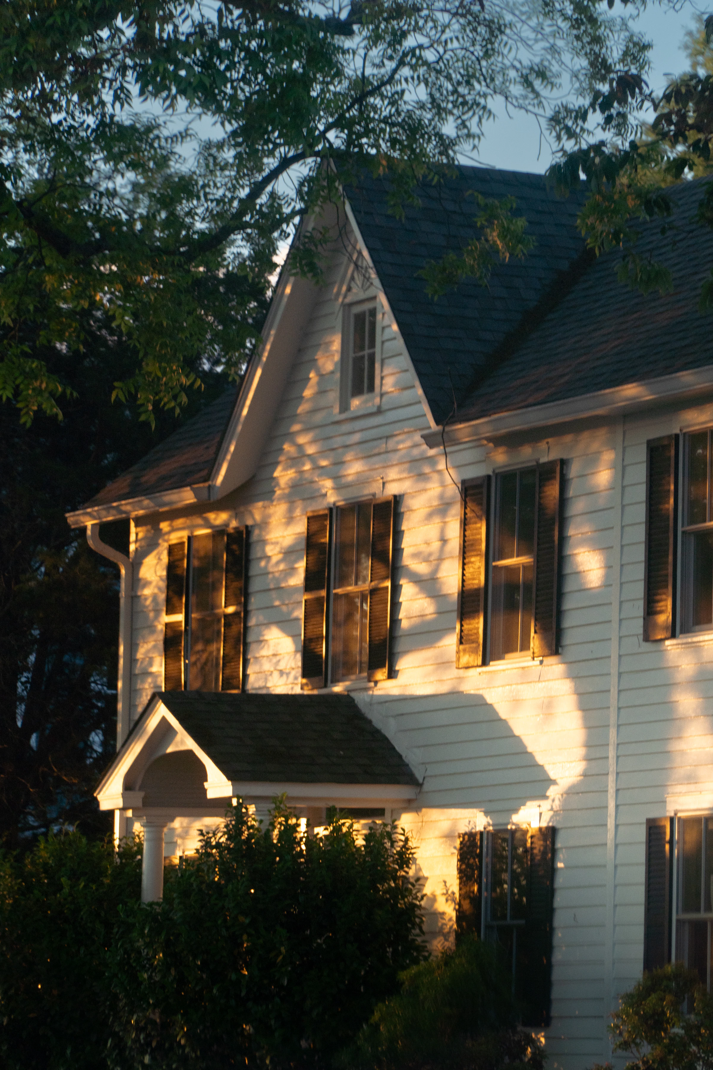Classic home exterior lit by warm evening sunlight