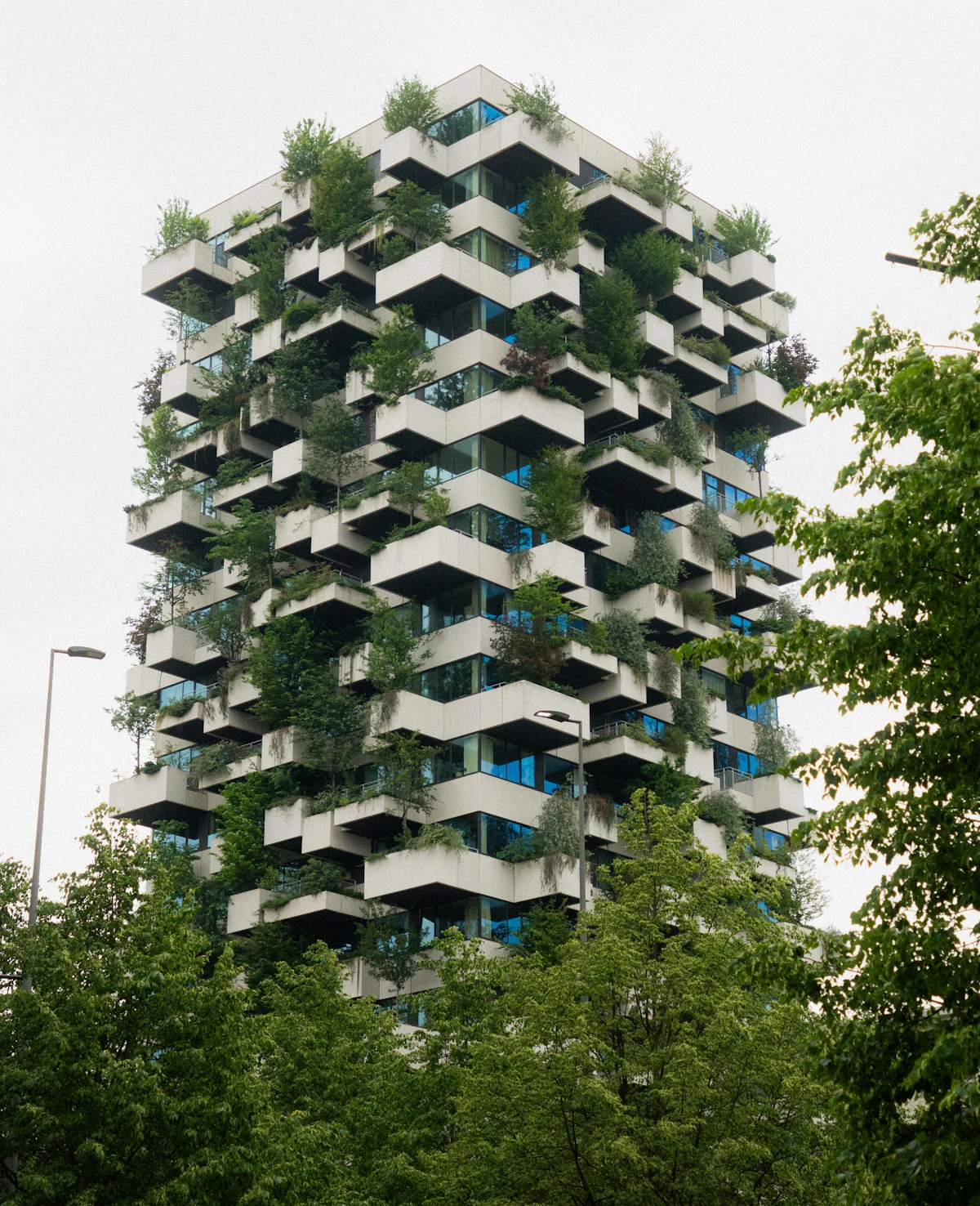 A modern residential building with planted balconies
