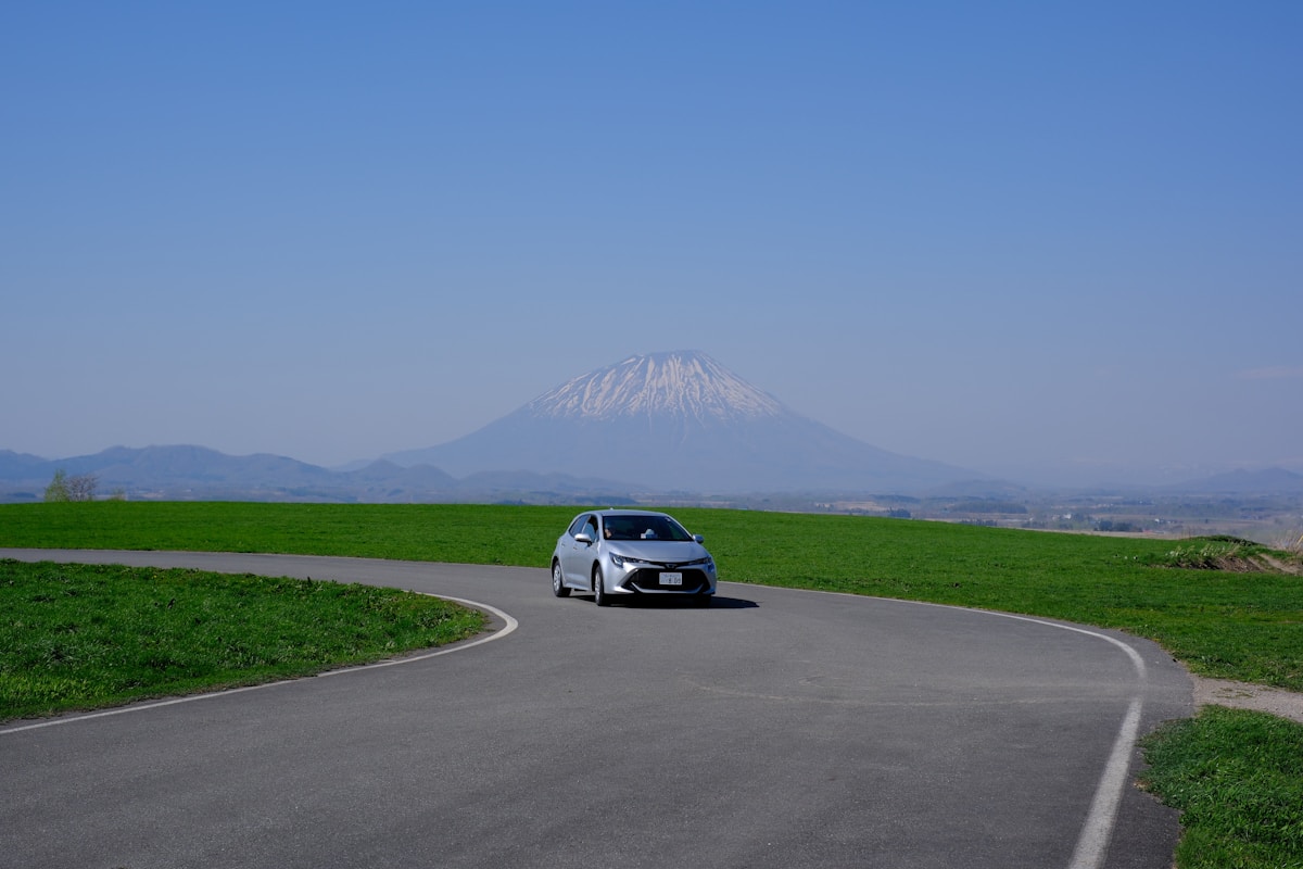 日本雪山下的蜿蜒山路與行駛中的轎車自駕風景