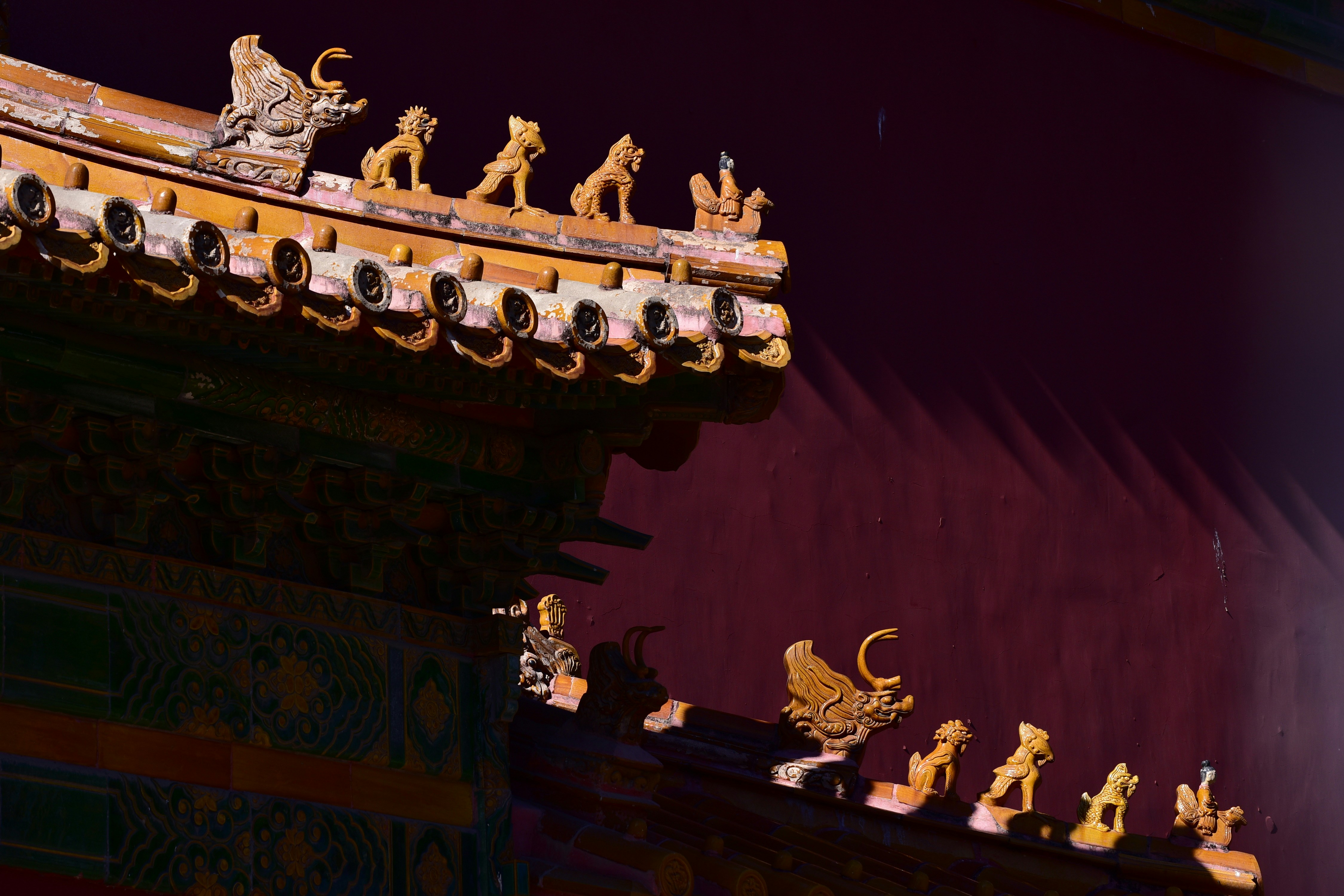 Ornate traditional chinese rooftops with decorative animal figures.