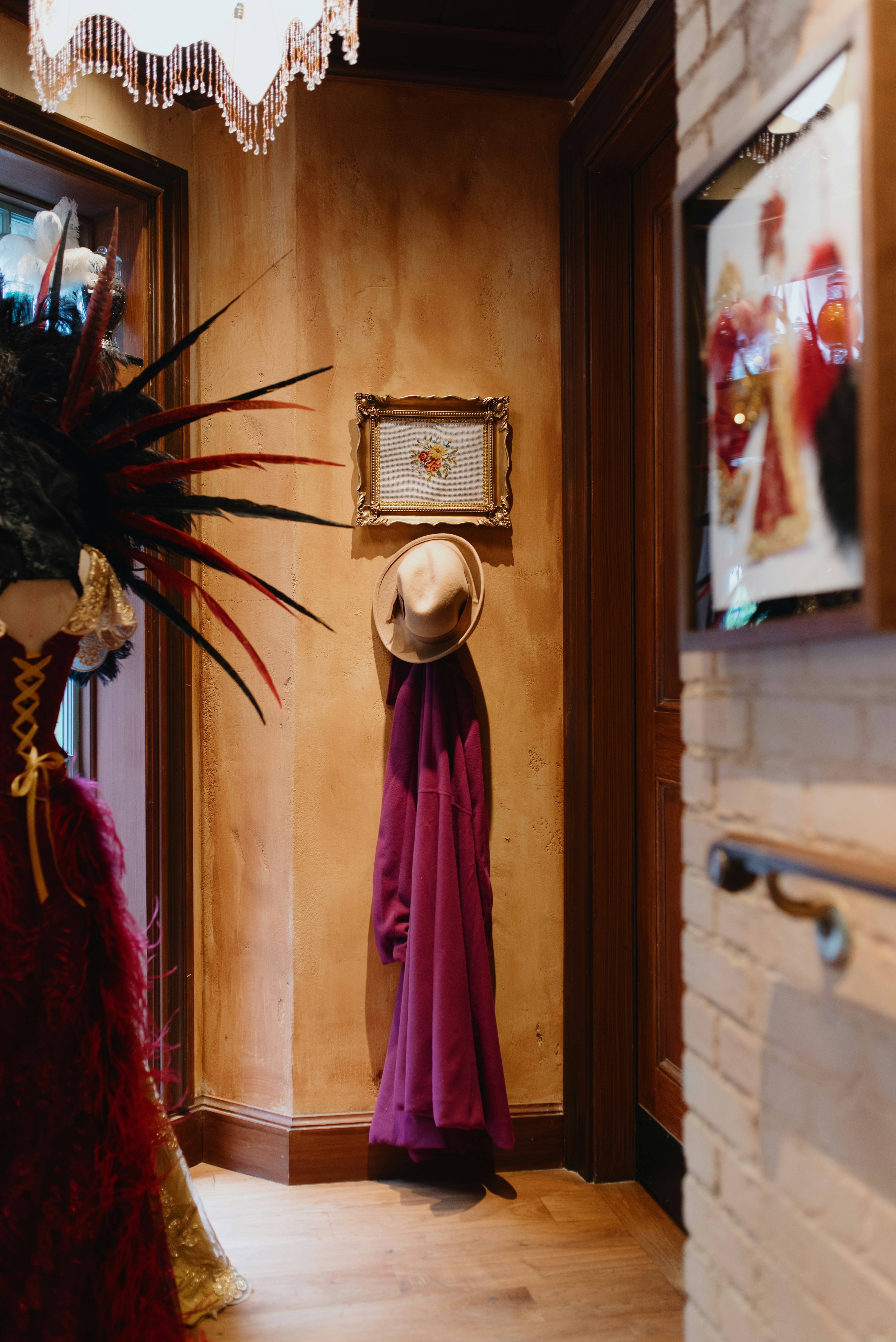 Pasillo ornamentado con sombrero, abrigo morado y disfraz de plumas