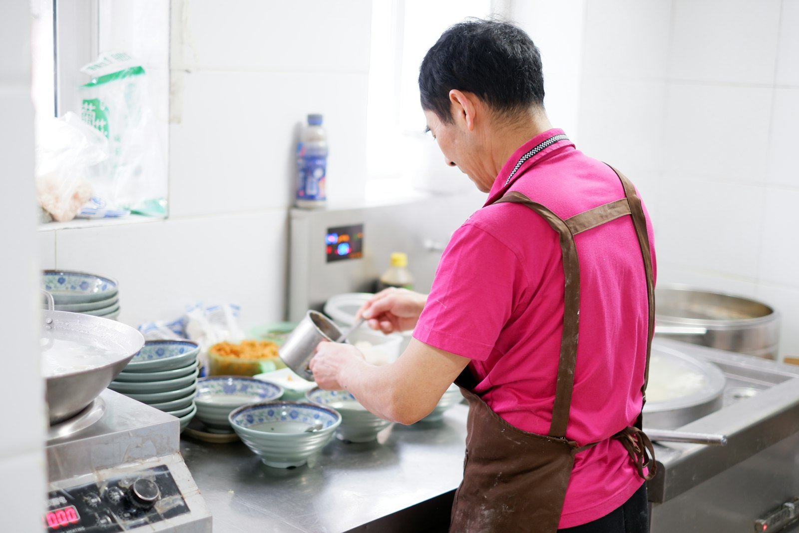 Worker in a kitchen workplace preparing food in a professional uniform