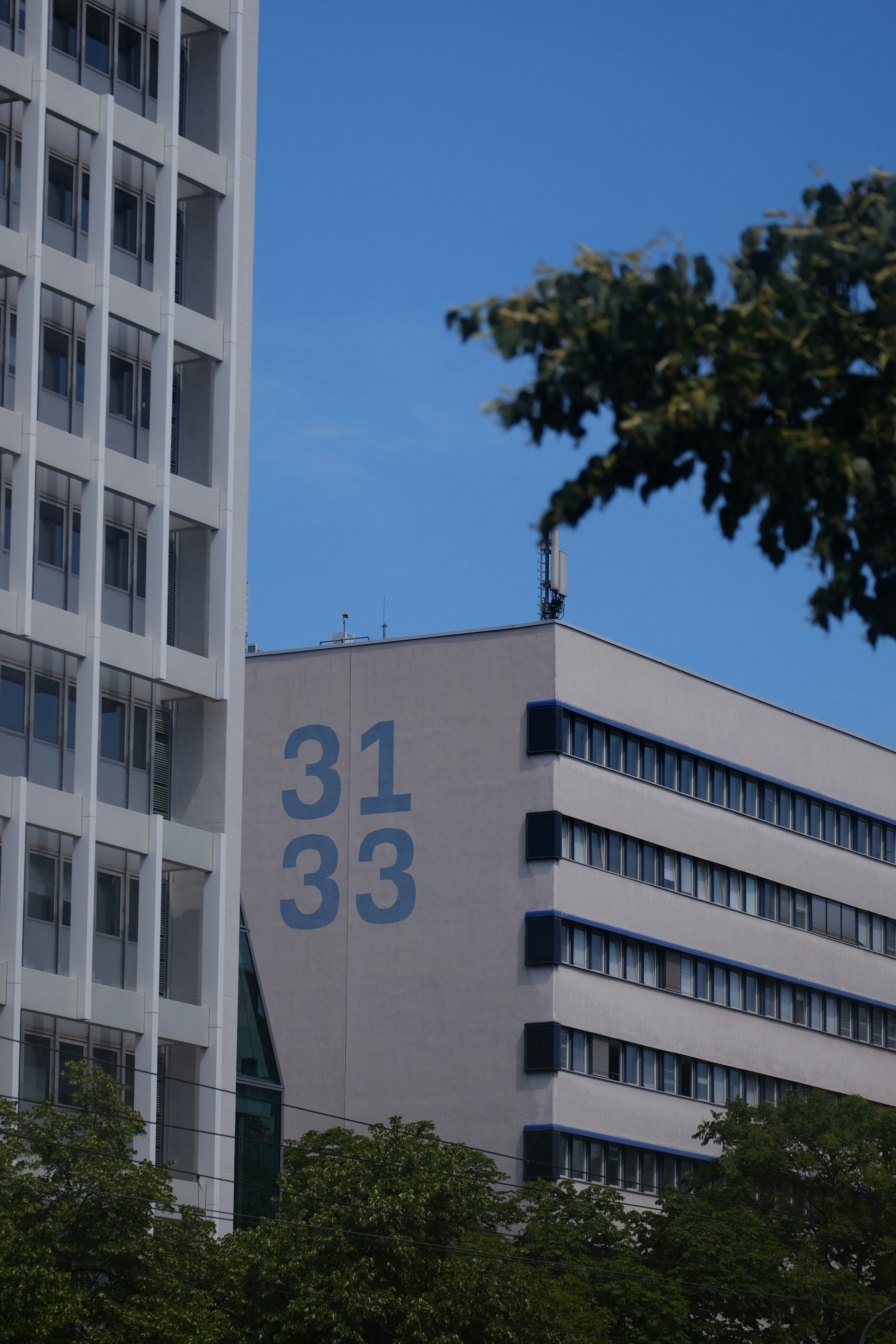 Edificios modernos con los números 31 33 bajo un cielo azul.
