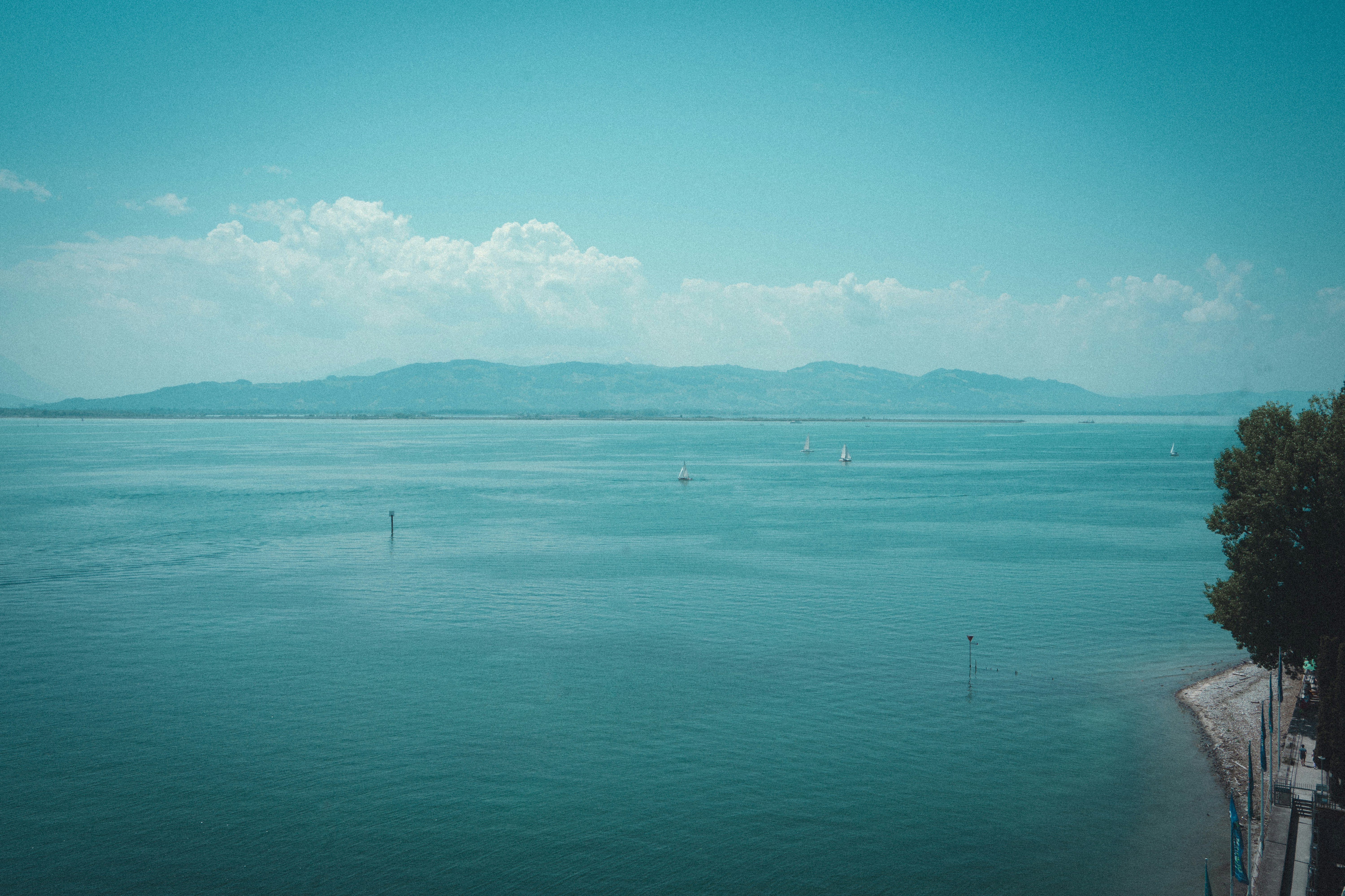 Weites blaues Wasser mit fernen Bergen unter klarem Himmel.