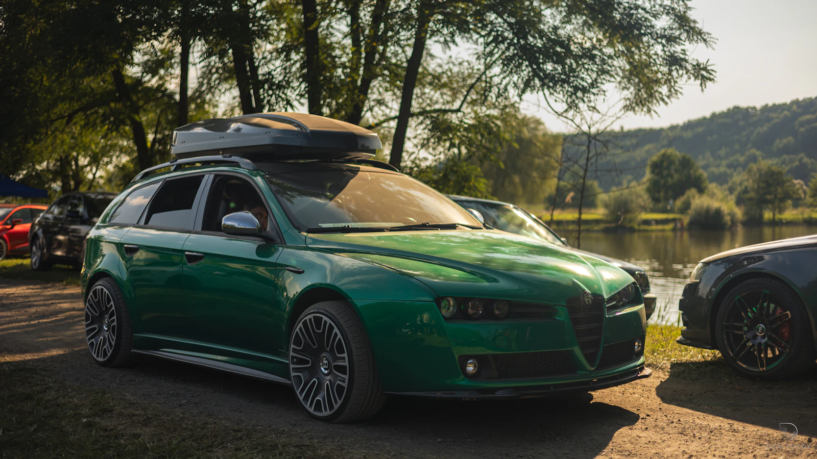 A car with a roof box by the water