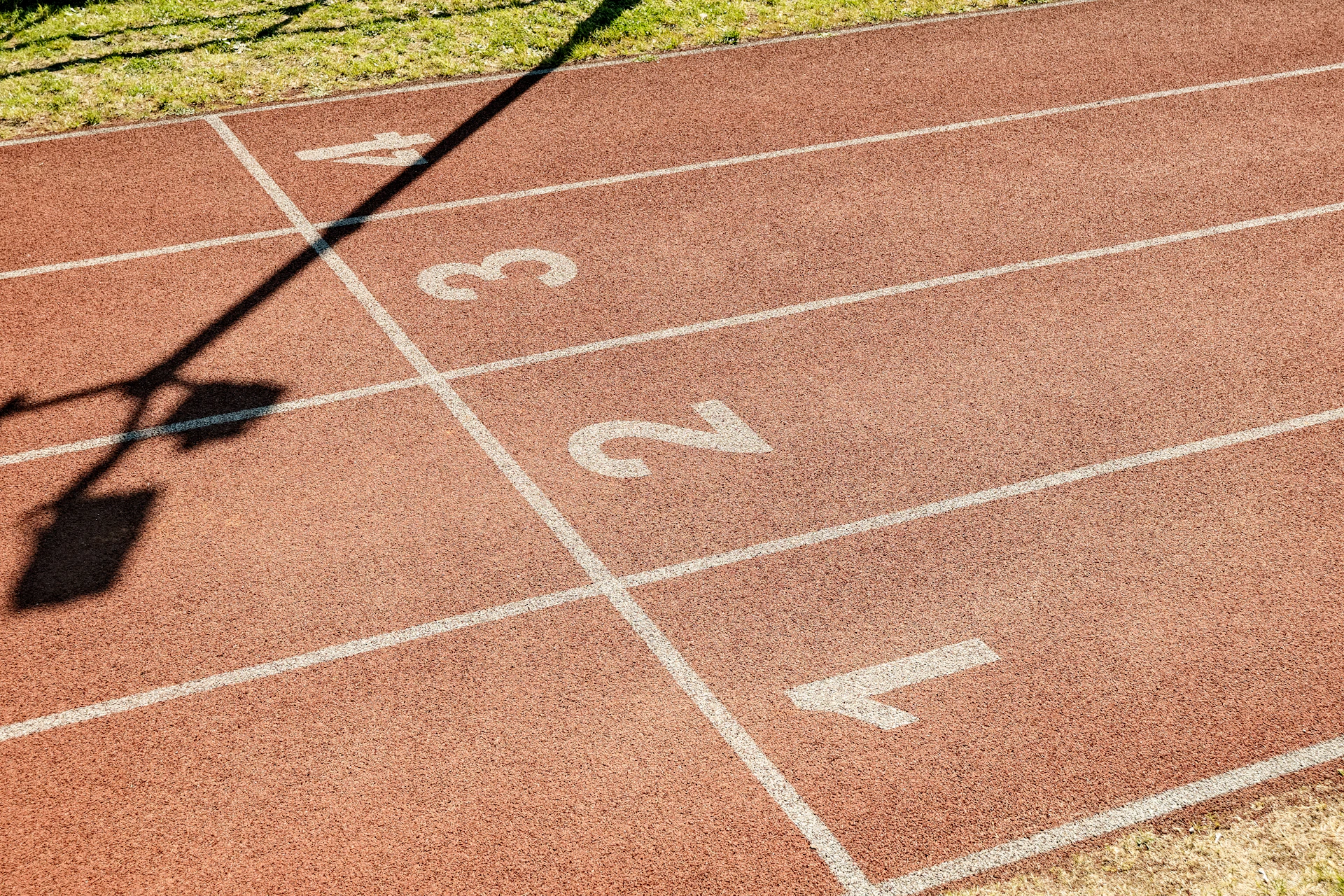 Empty red running track with lane numbers.