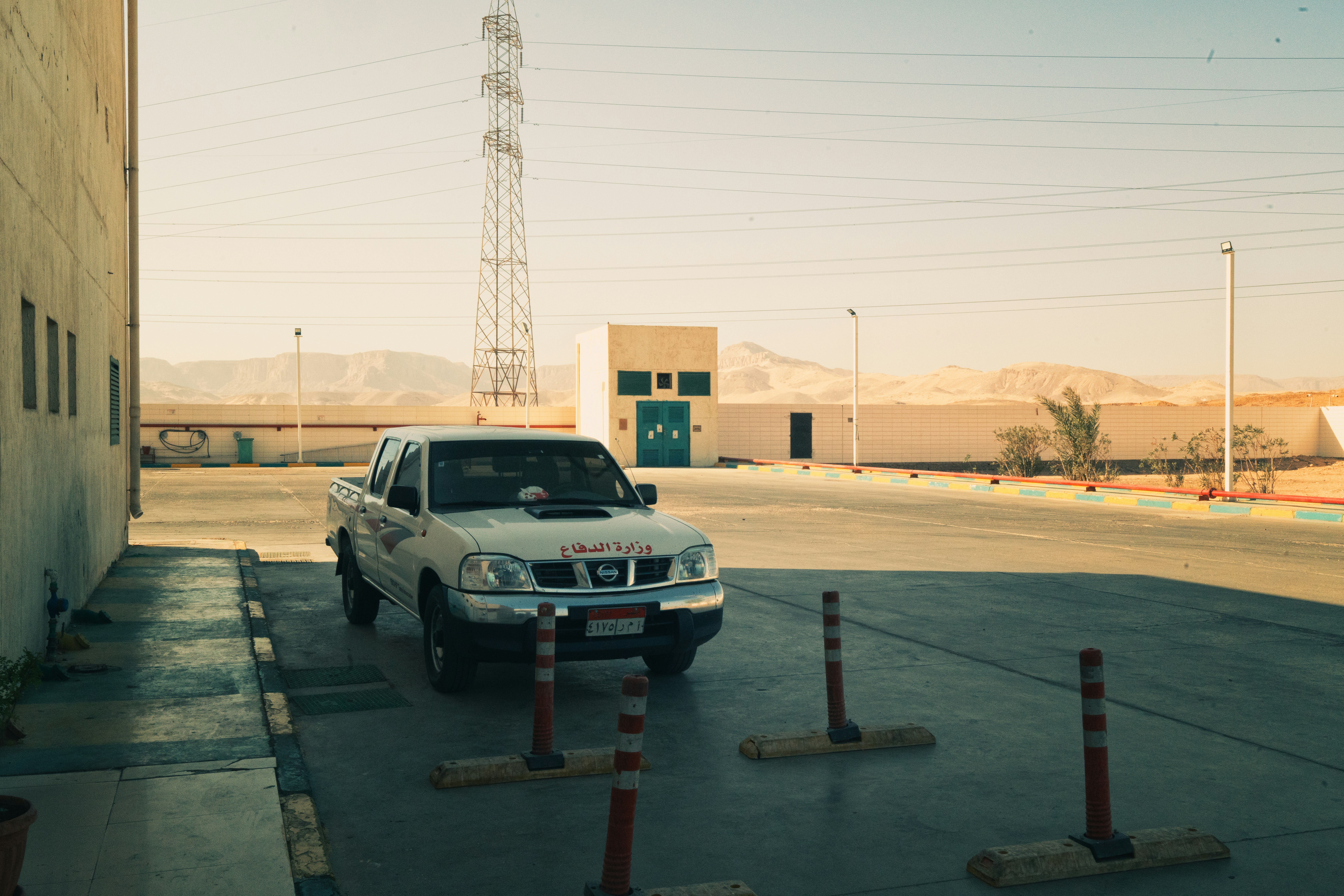 White pickup truck in an arid industrial landscape.