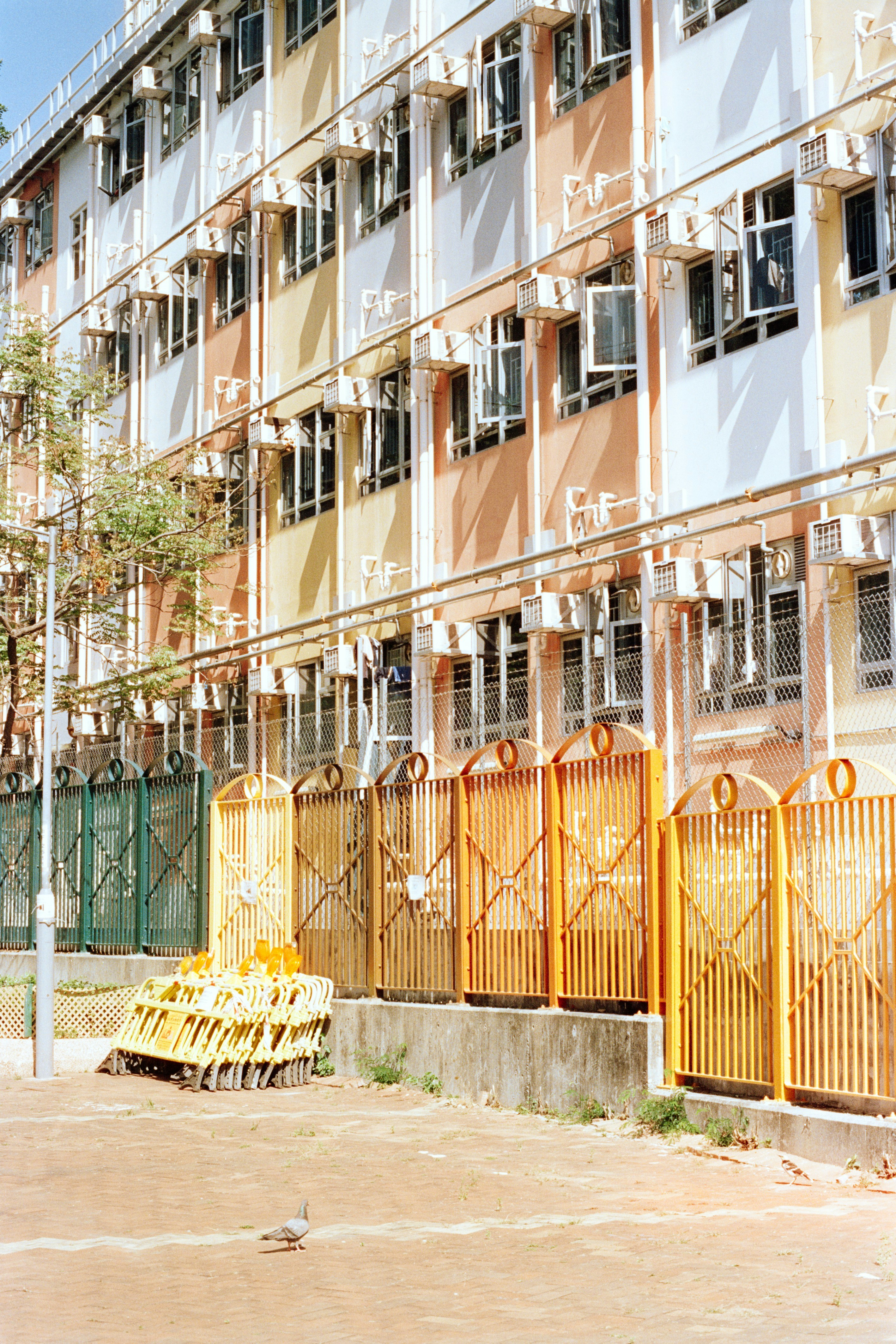 Edificio di appartamenti colorato con molte finestre e cancelli gialli.