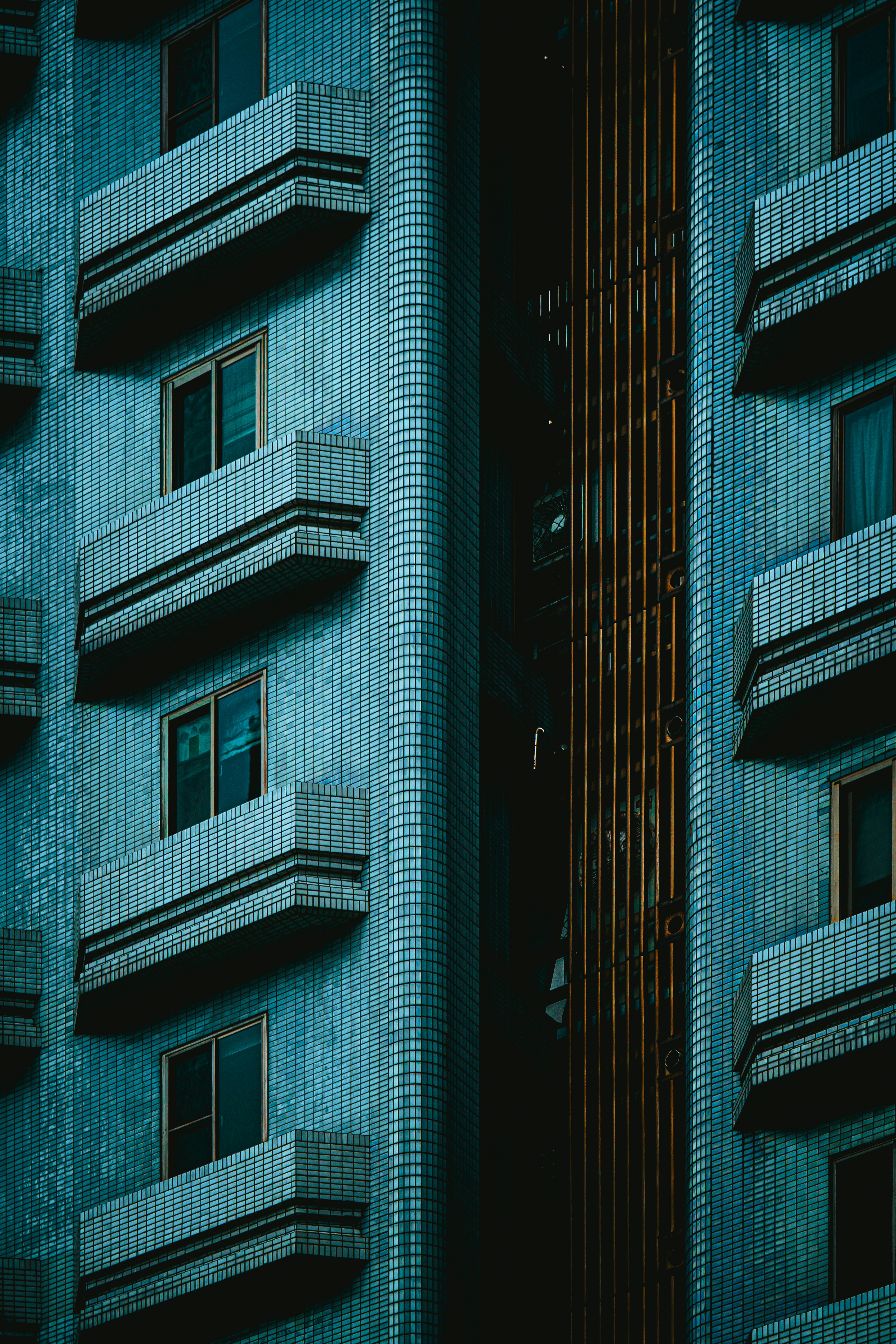 Rows of balconies on a blue tiled building exterior.