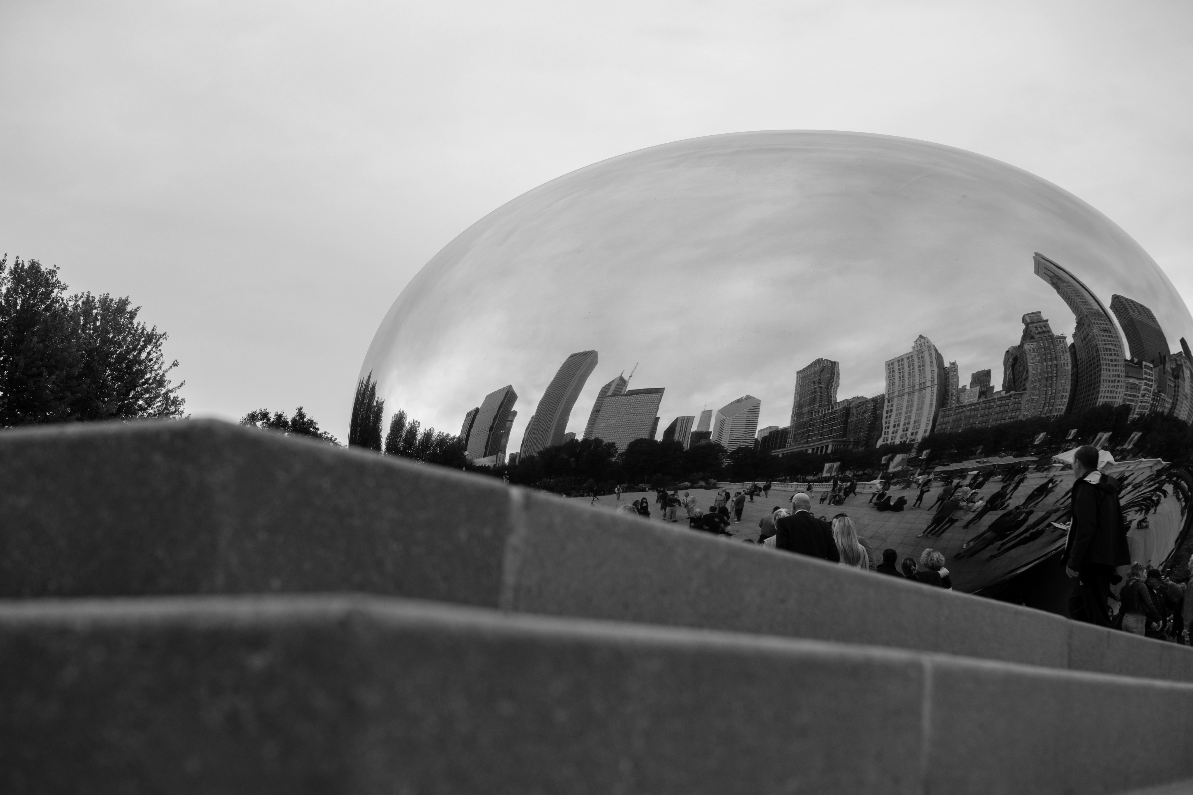 Black and white reflective sculpture showing city skyline.
