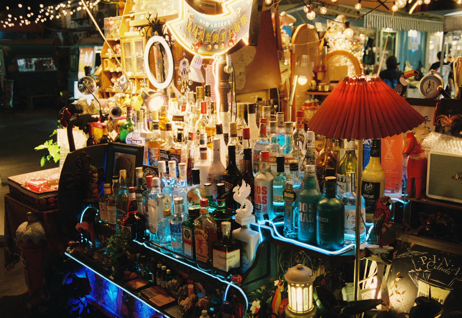 Vibrant bar counter with illuminated bottles at night