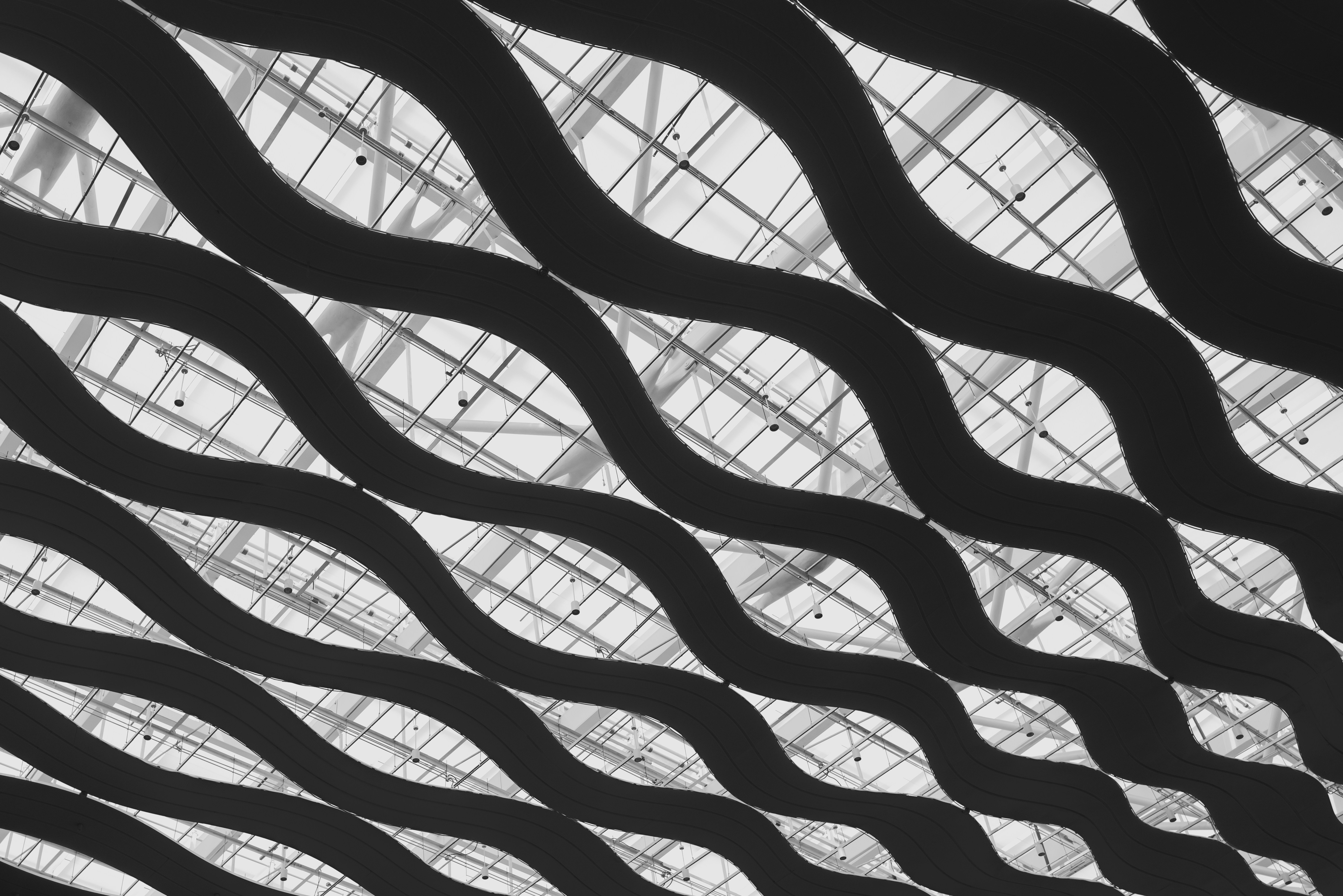 Diagonal wavy patterns on a modern architectural ceiling.