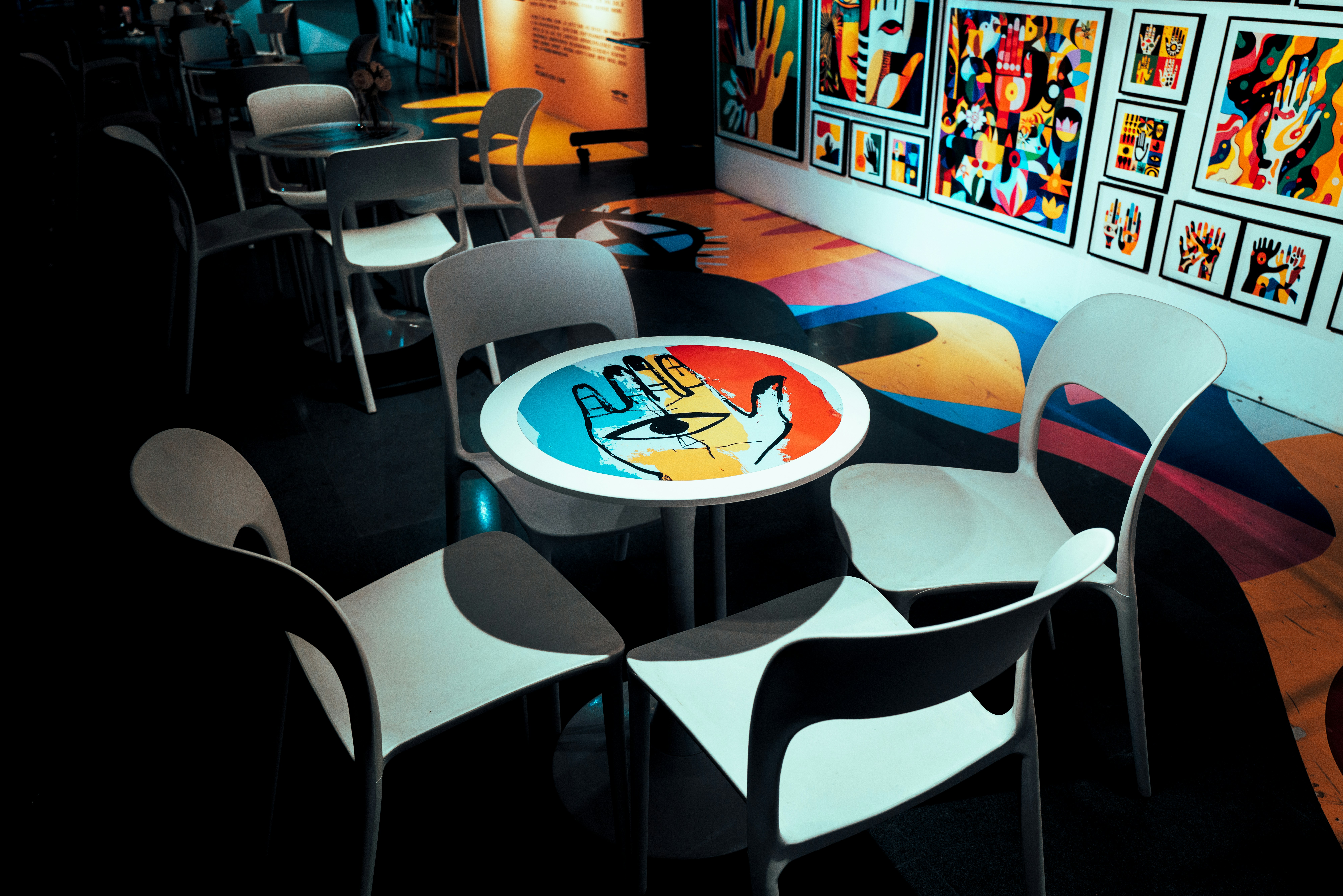 Un interno colorato di caffè con sedie uniche e opere d'arte murali.