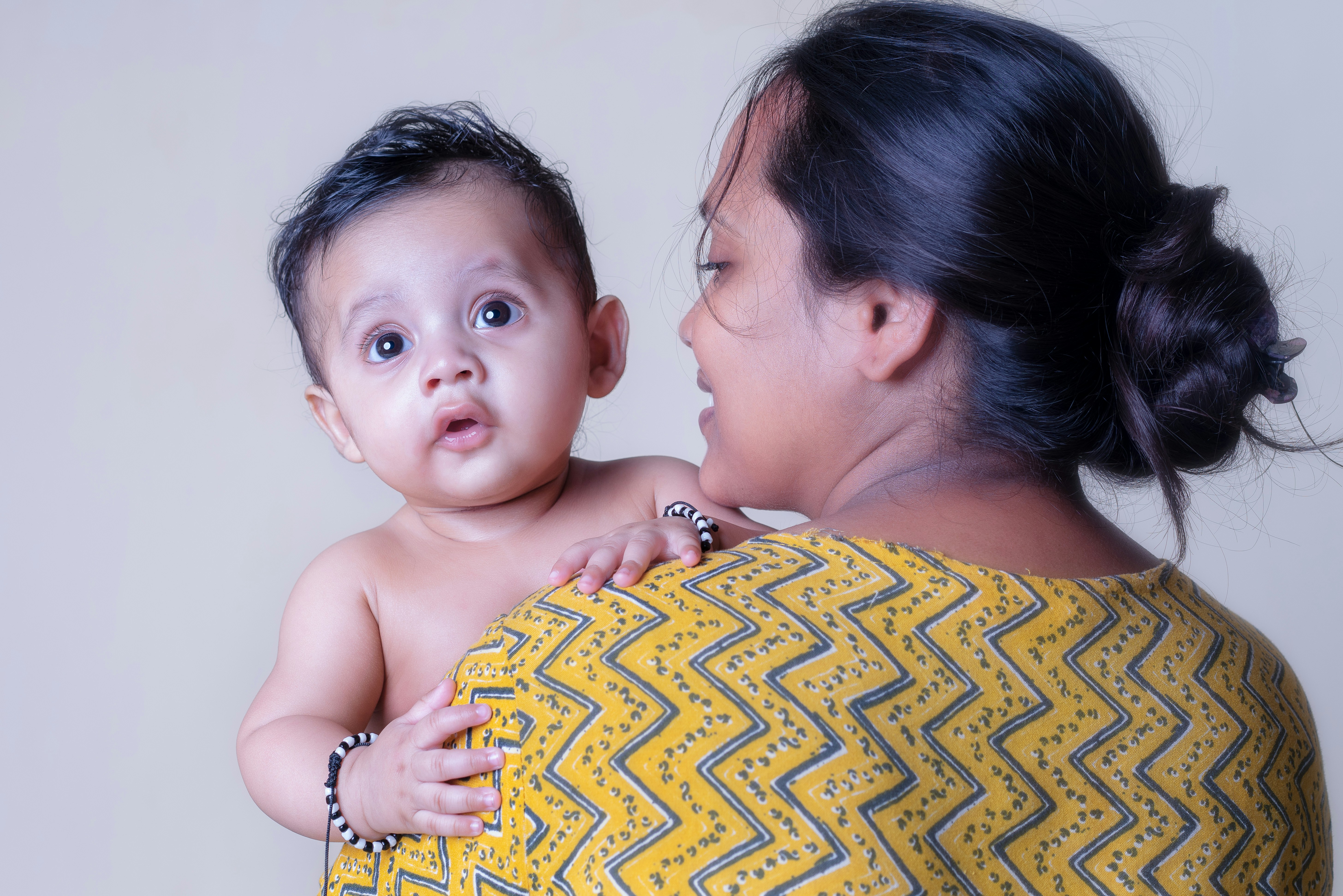 Seorang wanita menggendong bayi yang menatap langsung ke kamera.