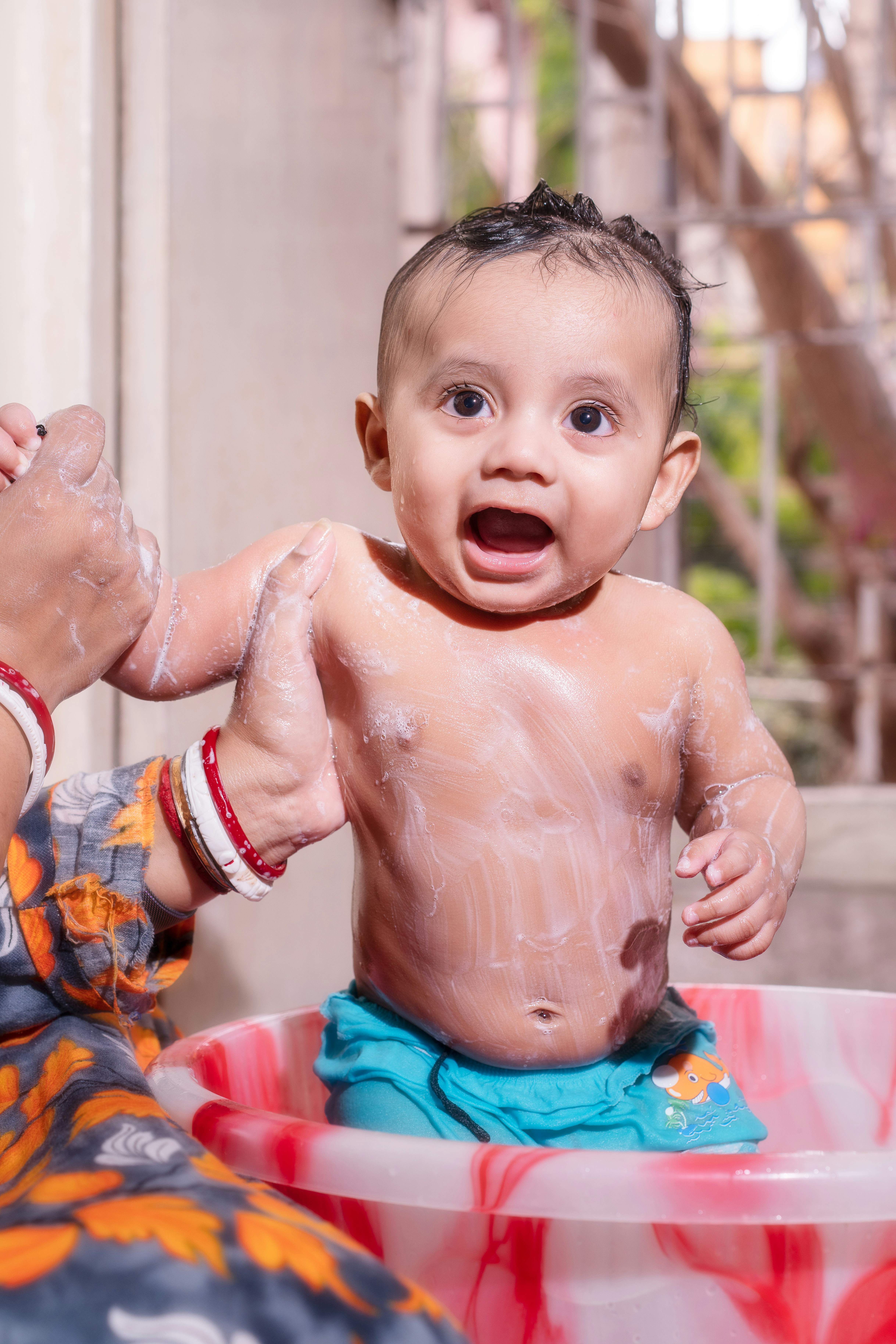 Adorable baby covered in soap enjoying a bath.