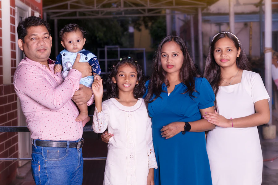 Familie candida la botez, parintii tinand copilul in brate