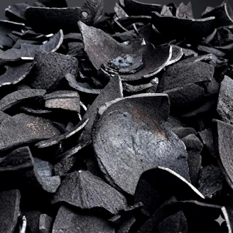 Dark, irregular pieces of coconut shell charcoal.