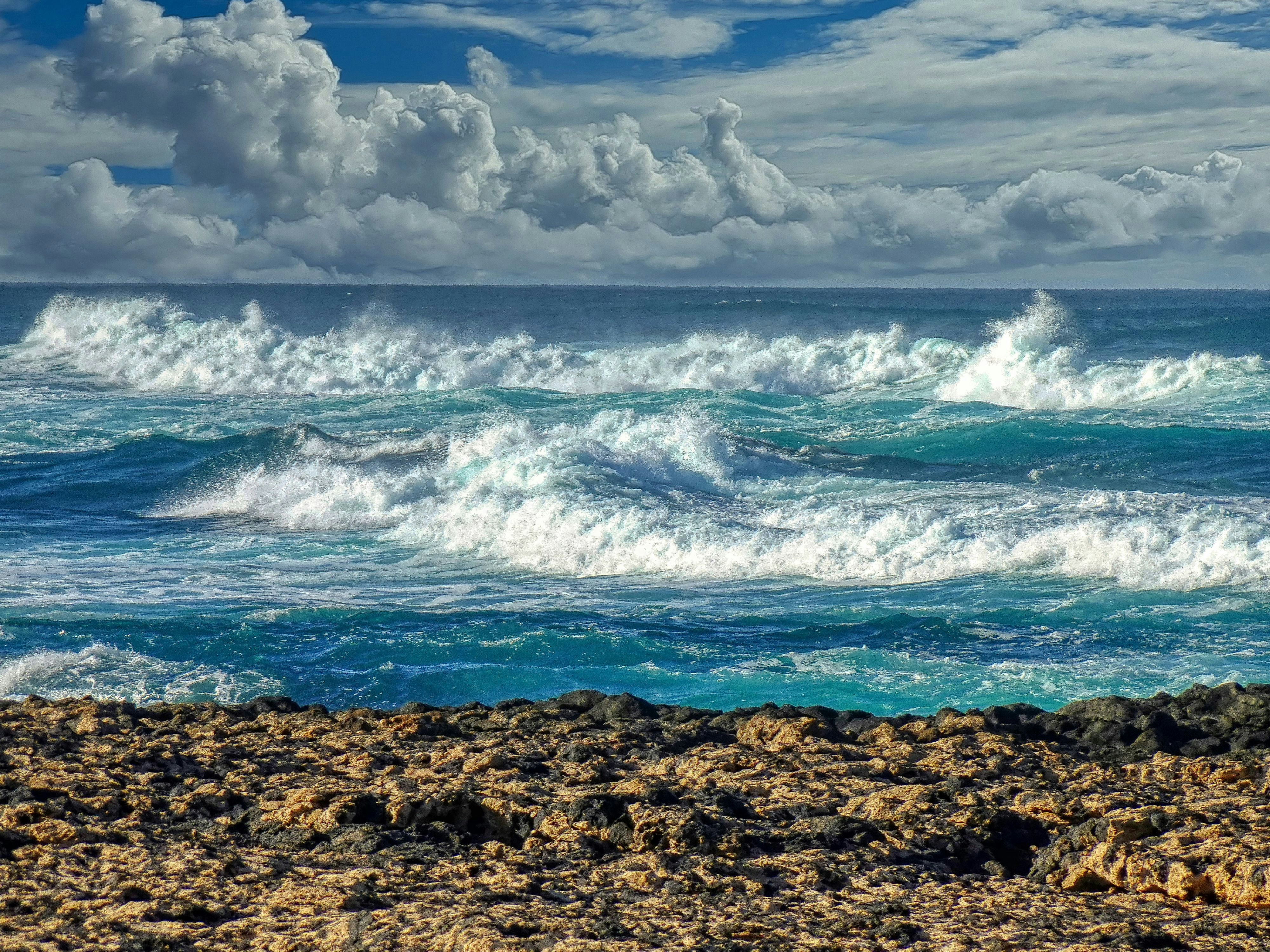 Rough ocean waves crashing under a cloudy sky.