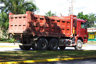 Red dump truck parked on a road.