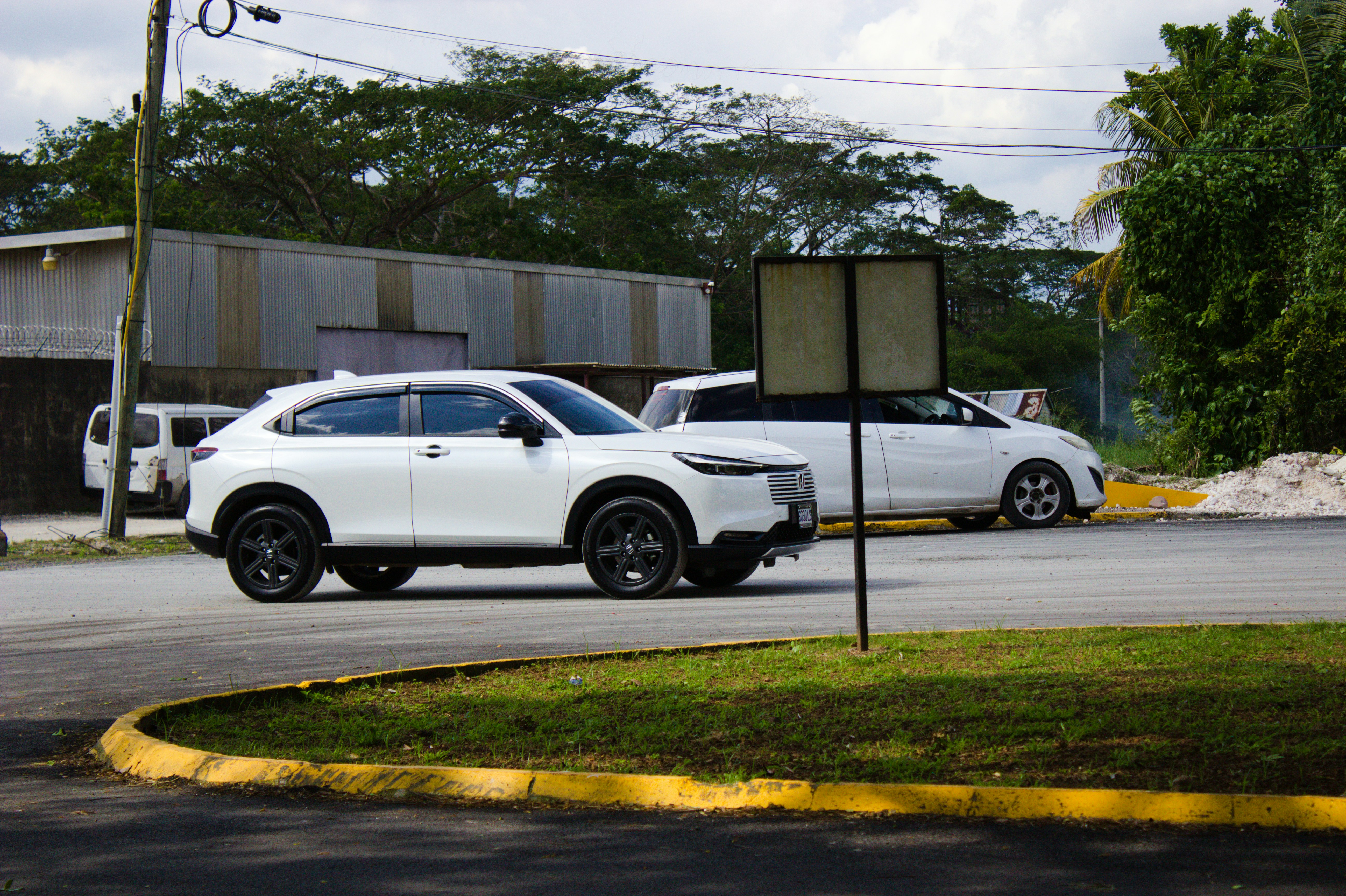 A white suv and another car parked near a building.