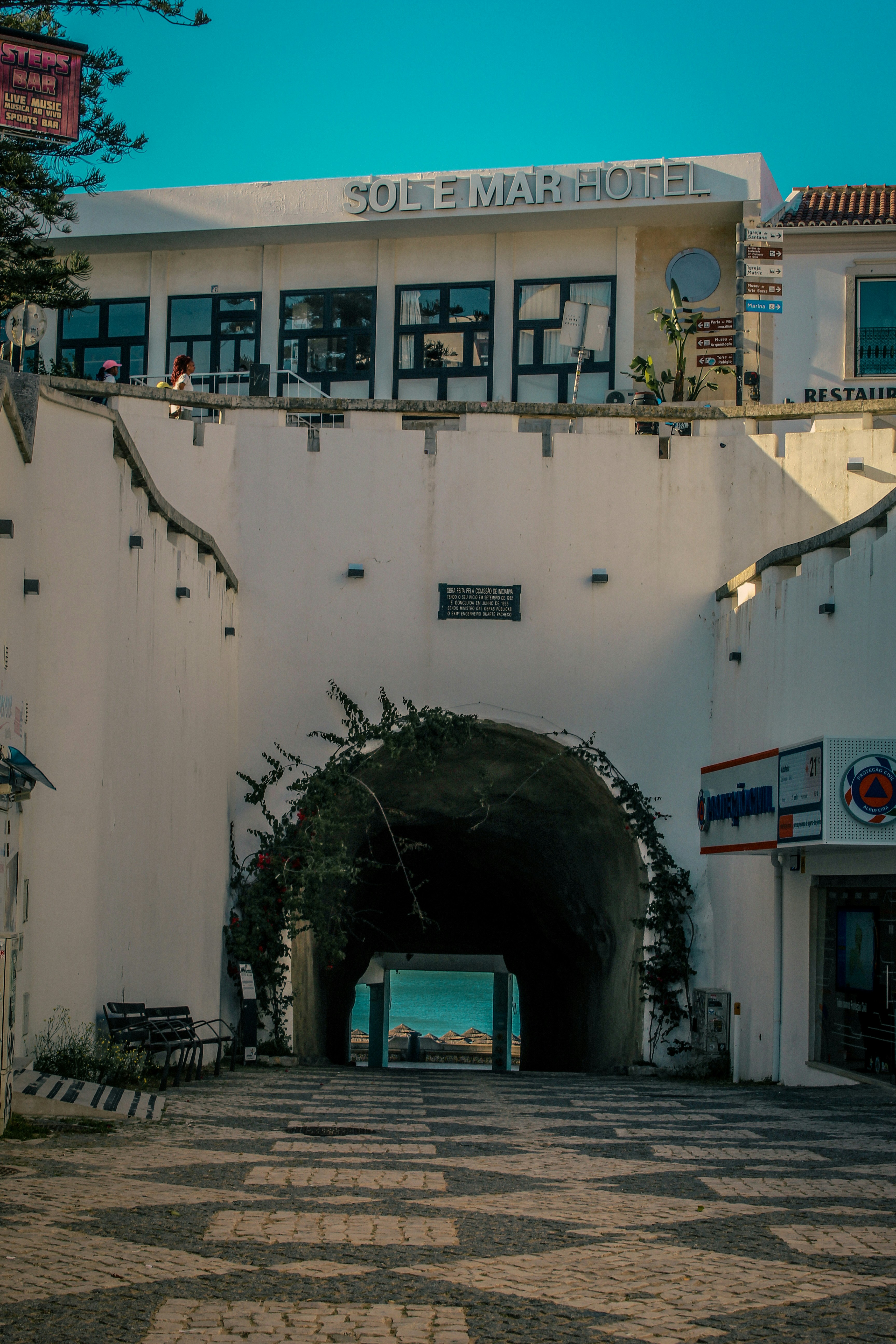 White archway opens to the sea under sole mar hotel.