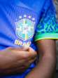 A hand touches a blue brazilian soccer jersey
