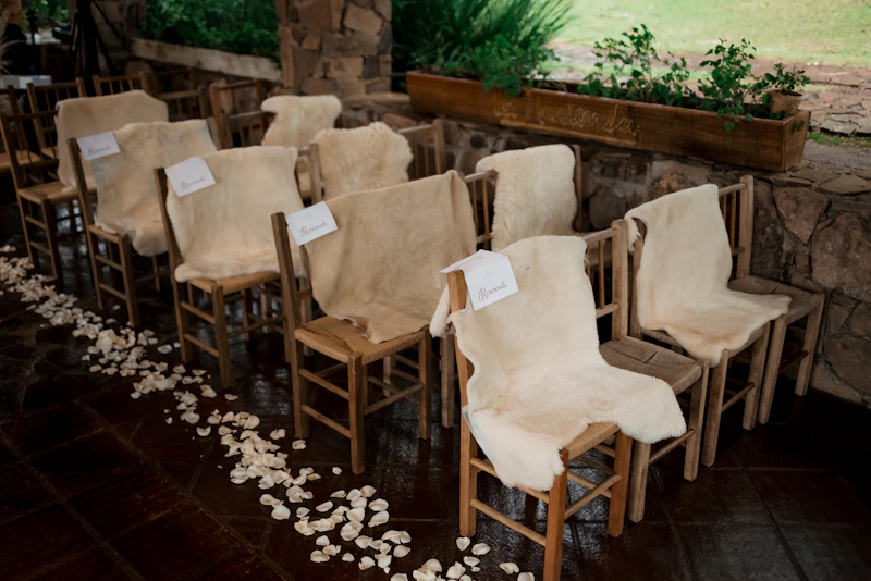 Barn ceremony aisle lined with petals and wooden chairs