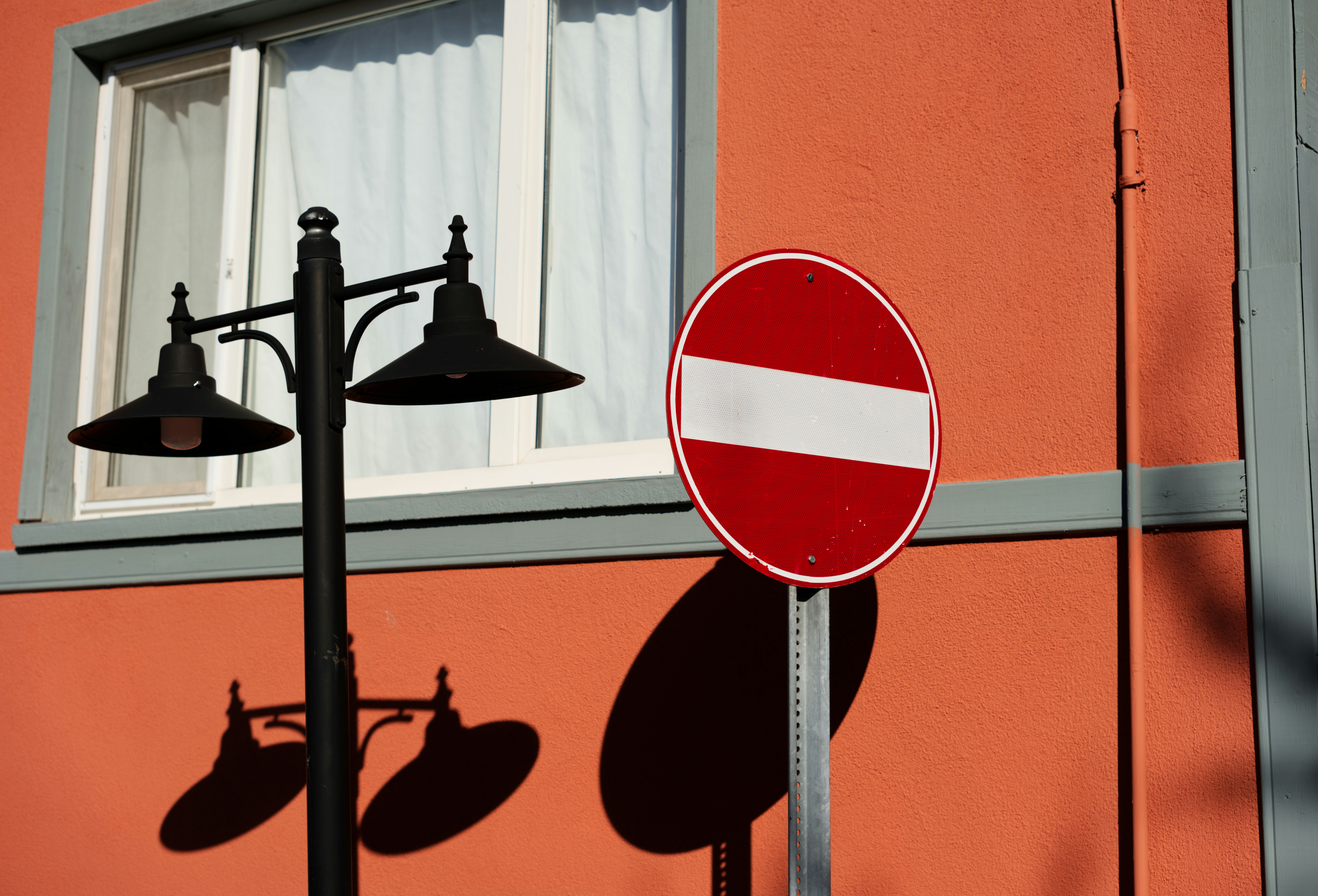 Nessun cartello d'ingresso, lampione e finestra sull'edificio arancione.