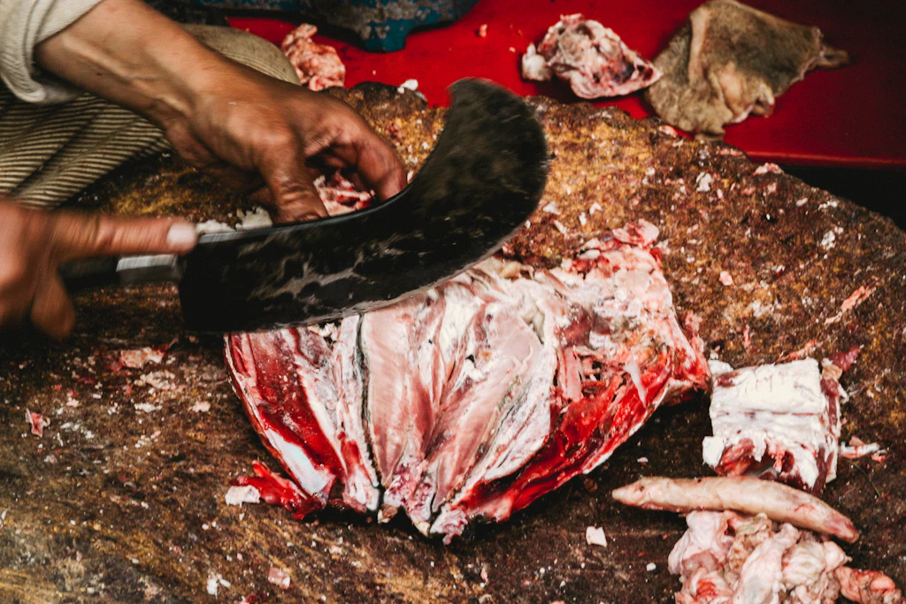 A butcher cutting fresh beef by hand