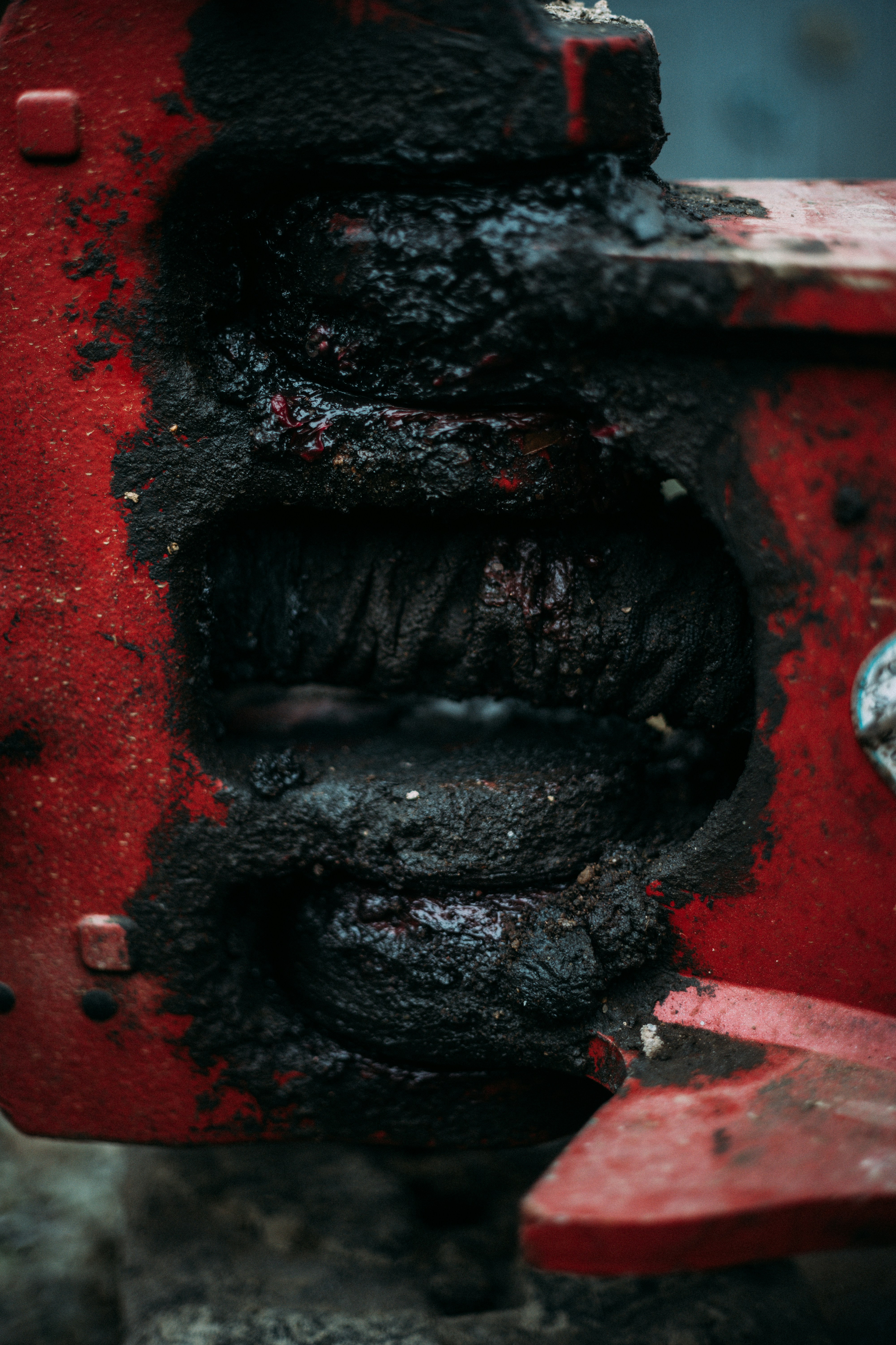 Close-up of a dirty, greasy red mechanical part