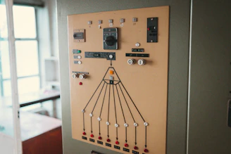 An old, beige control panel with buttons, dials, and lights.