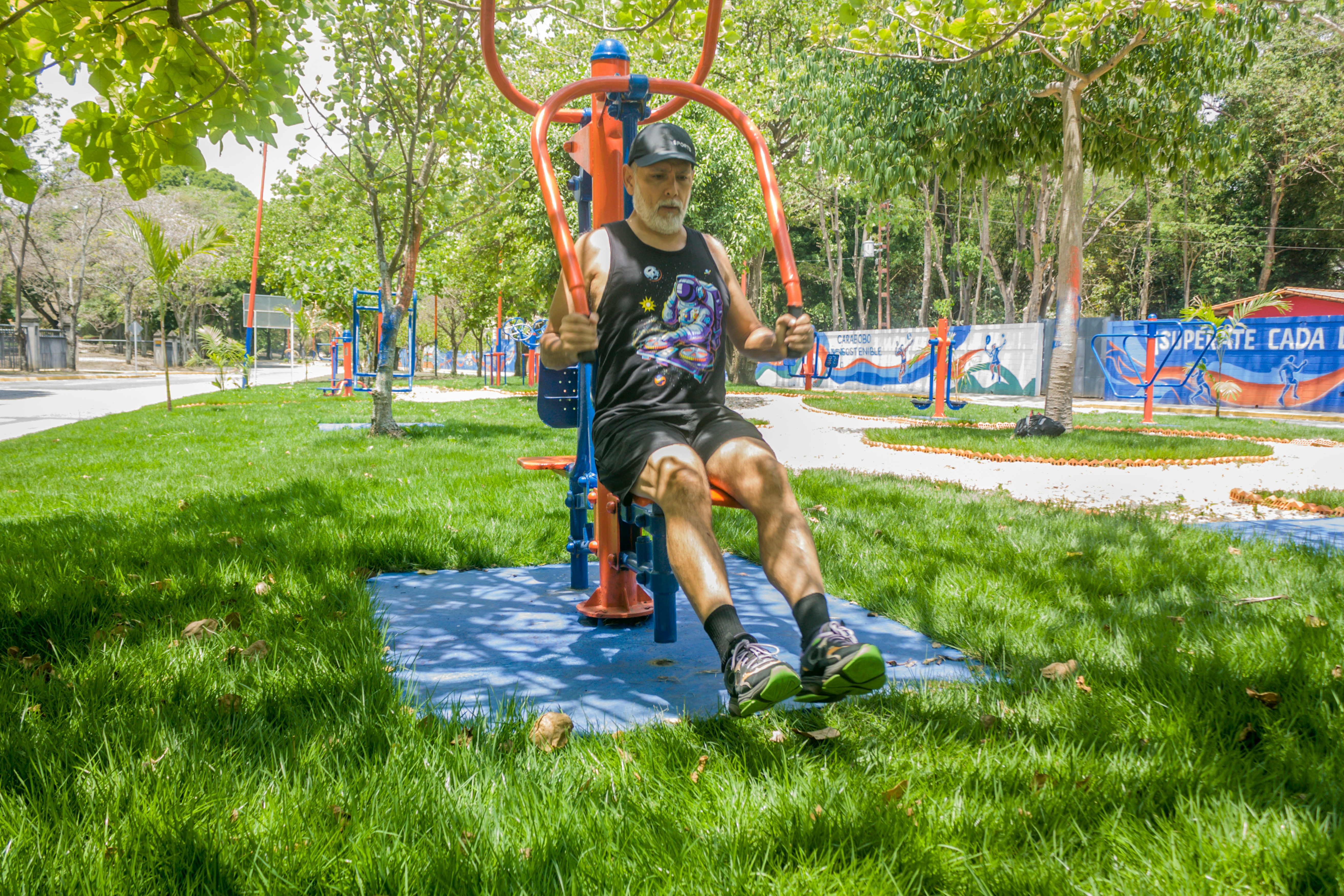 Man exercising on outdoor gym equipment in a park