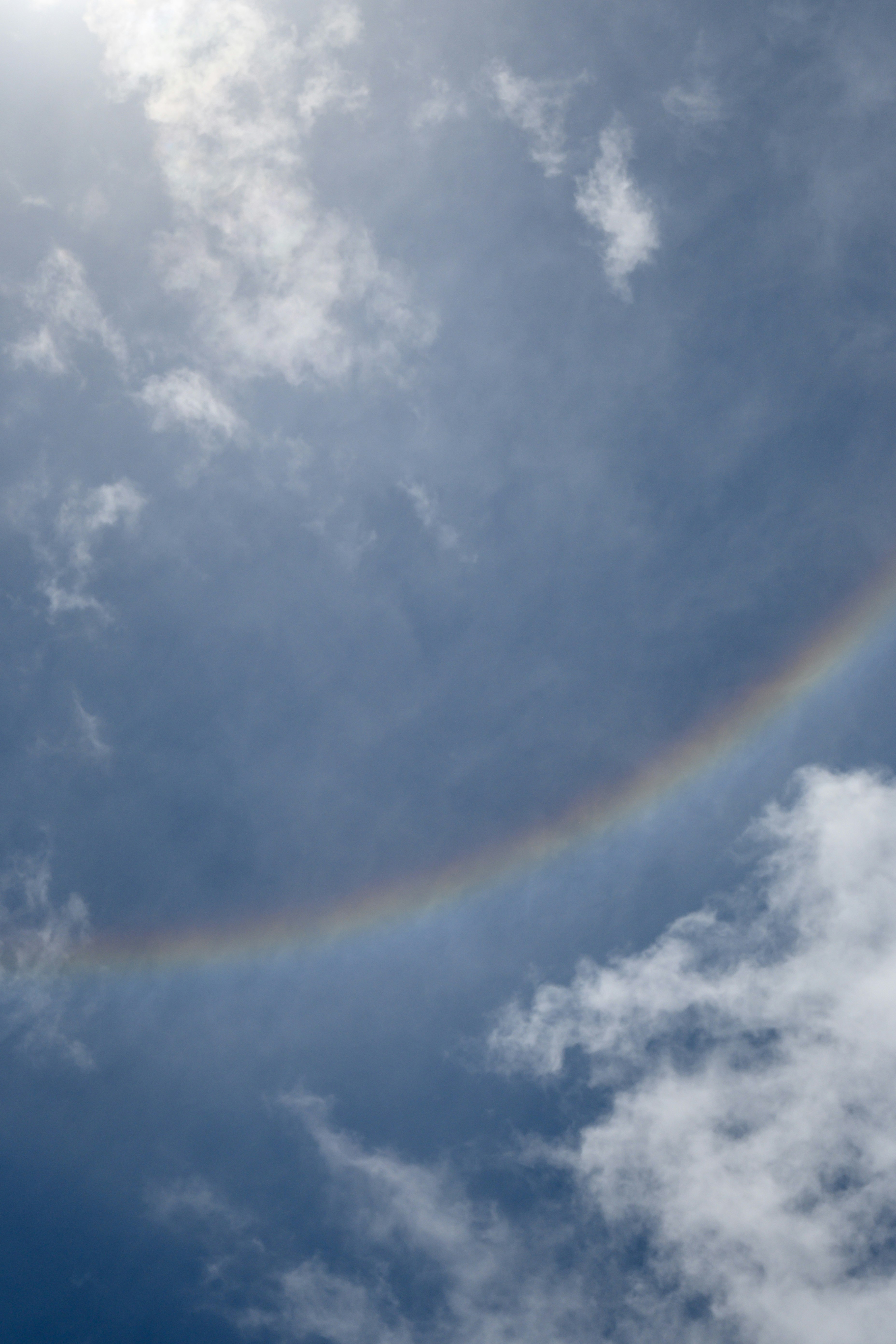 Un bellissimo alone solare in un cielo nuvoloso e azzurro brillante.