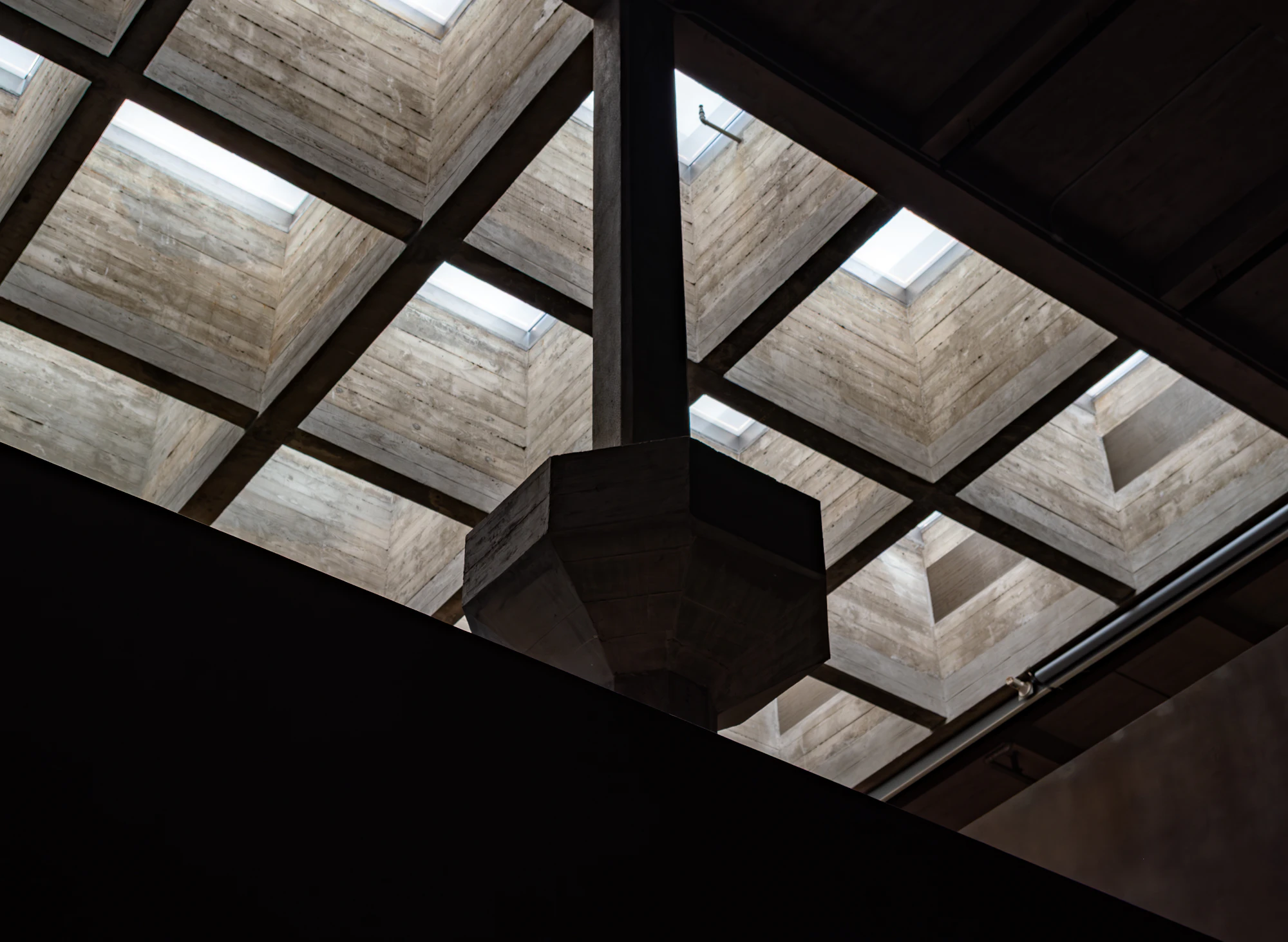A concrete ceiling structure with repeating skylights