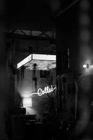 Black and white interior with a glowing "collab" neon sign.
